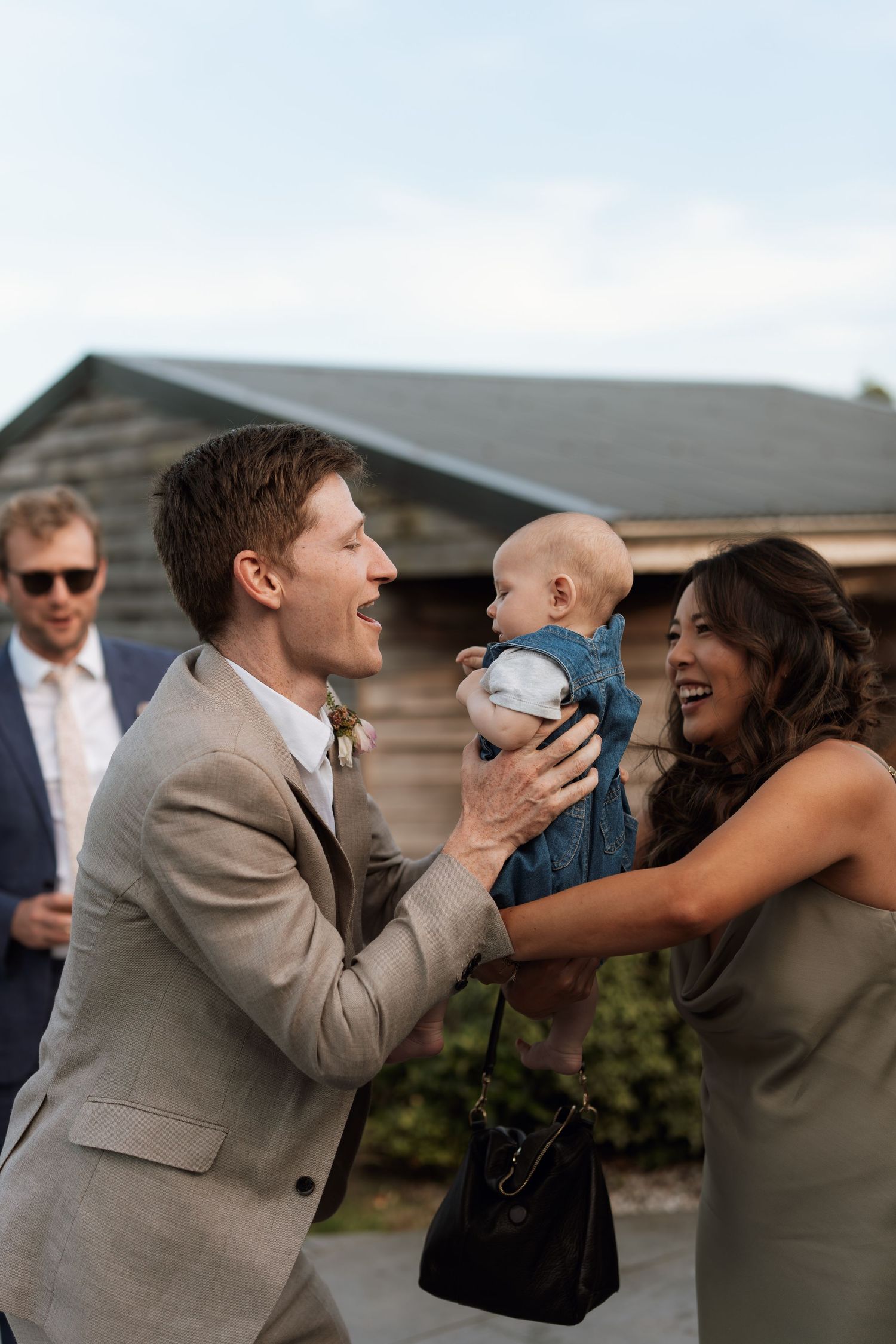 Wedding party members sharing laughs during outdoor photo session.