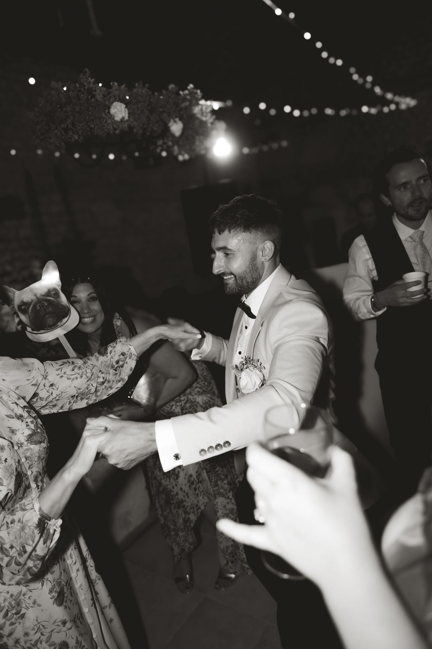 Black and white photo of energetic dancing at a wedding reception.
