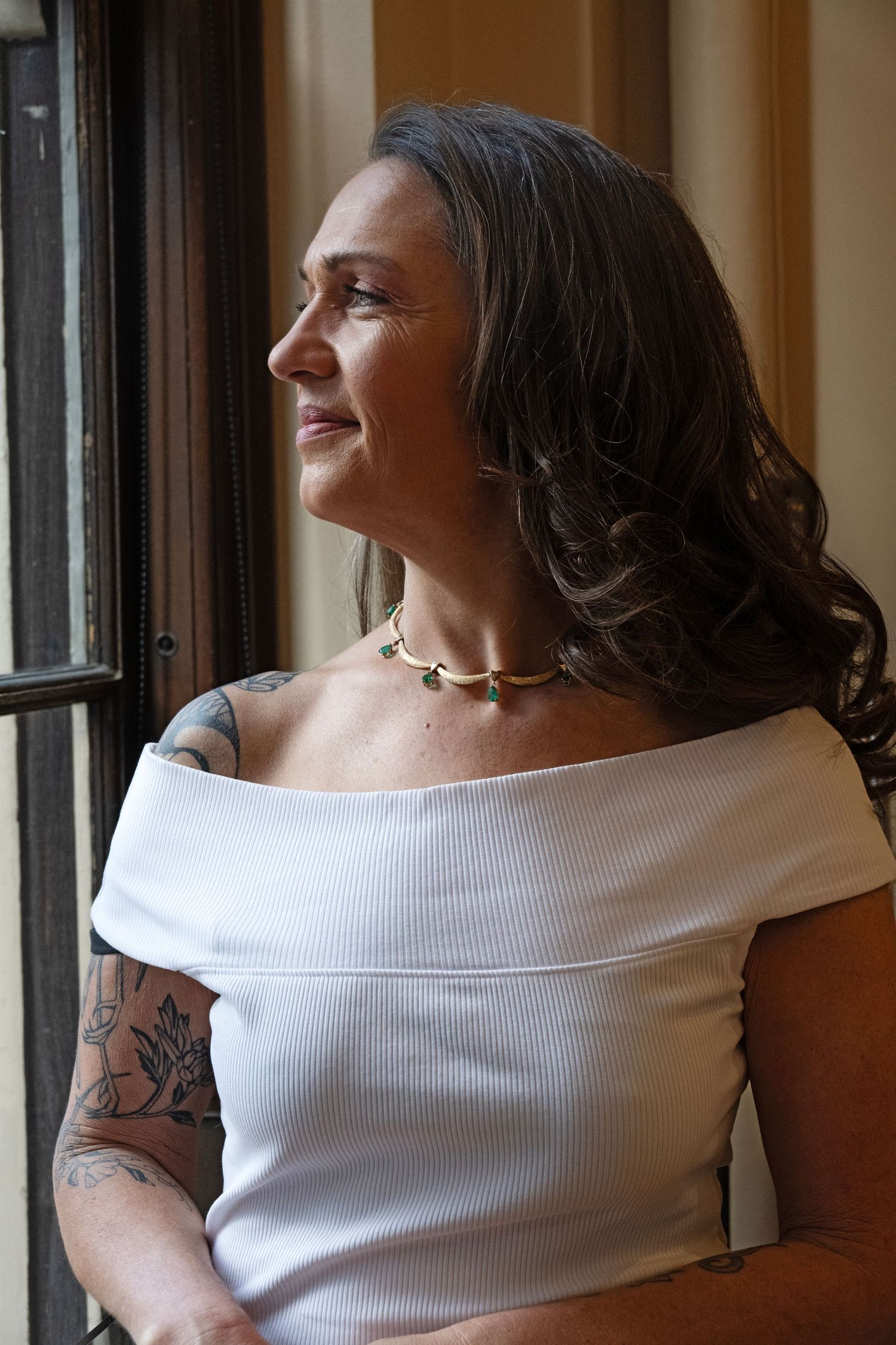 Lifestyle portrait of woman by window in soft natural light, photographed for personal branding and professional storytelling.