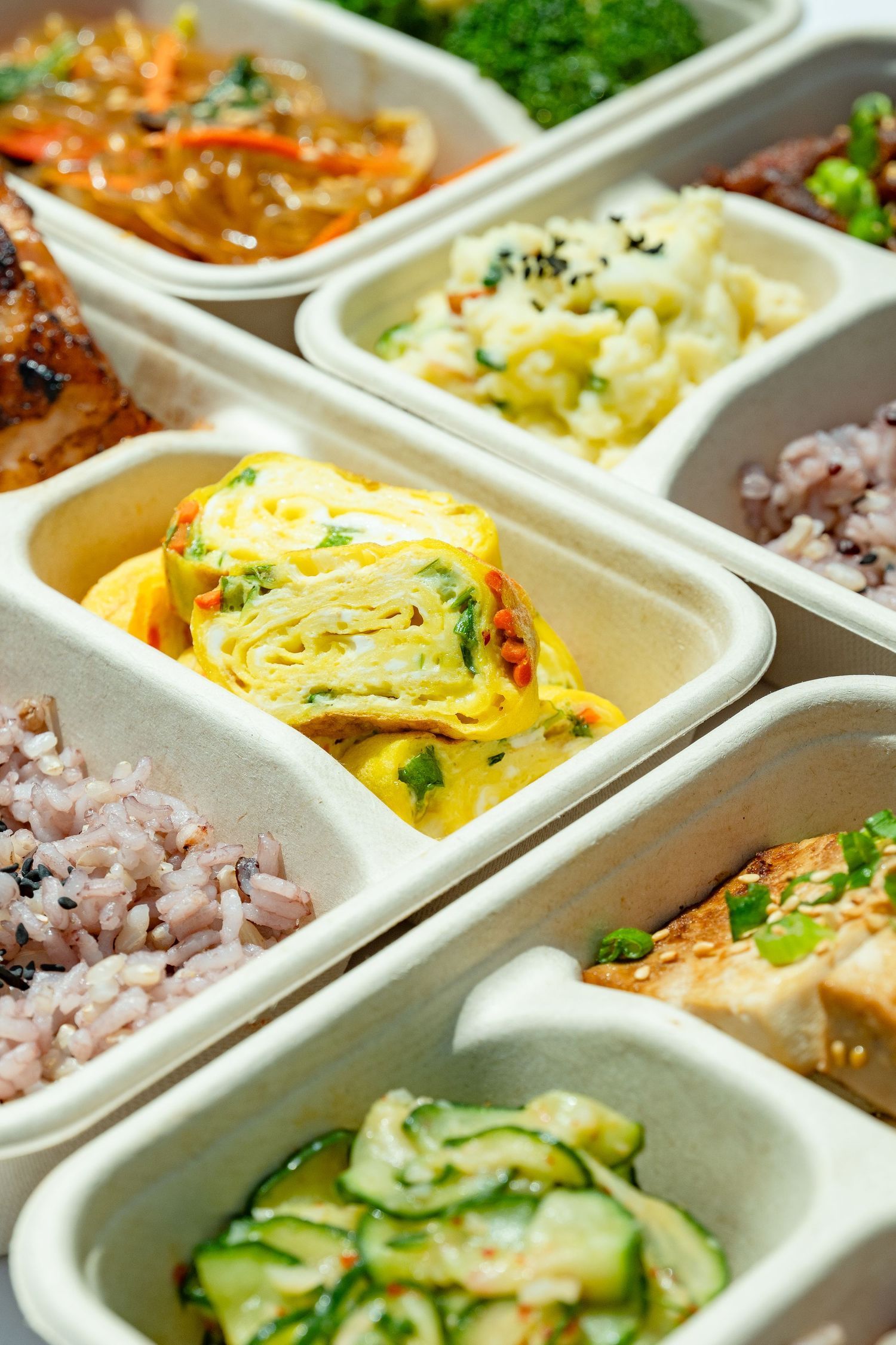 Korean bento box with rice, vegetables, and omelet, photographed for restaurant menus, delivery apps, and web use.