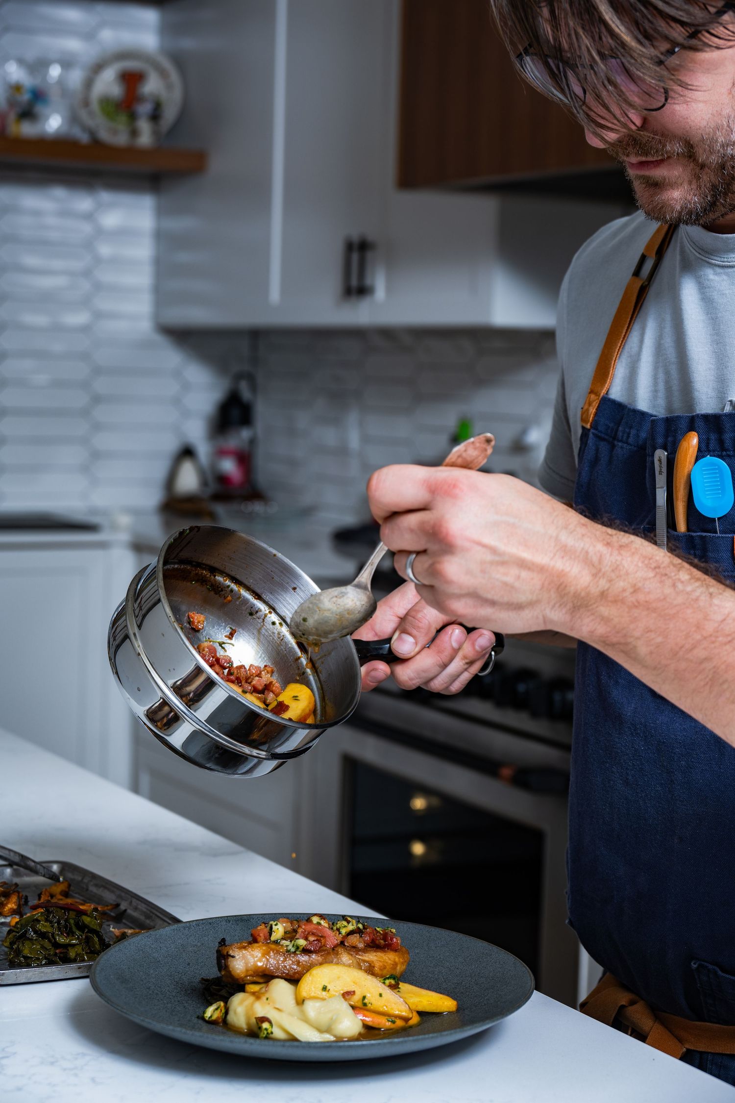 Chef plating restaurant dish in kitchen, photographed for culinary branding and lifestyle food photography.