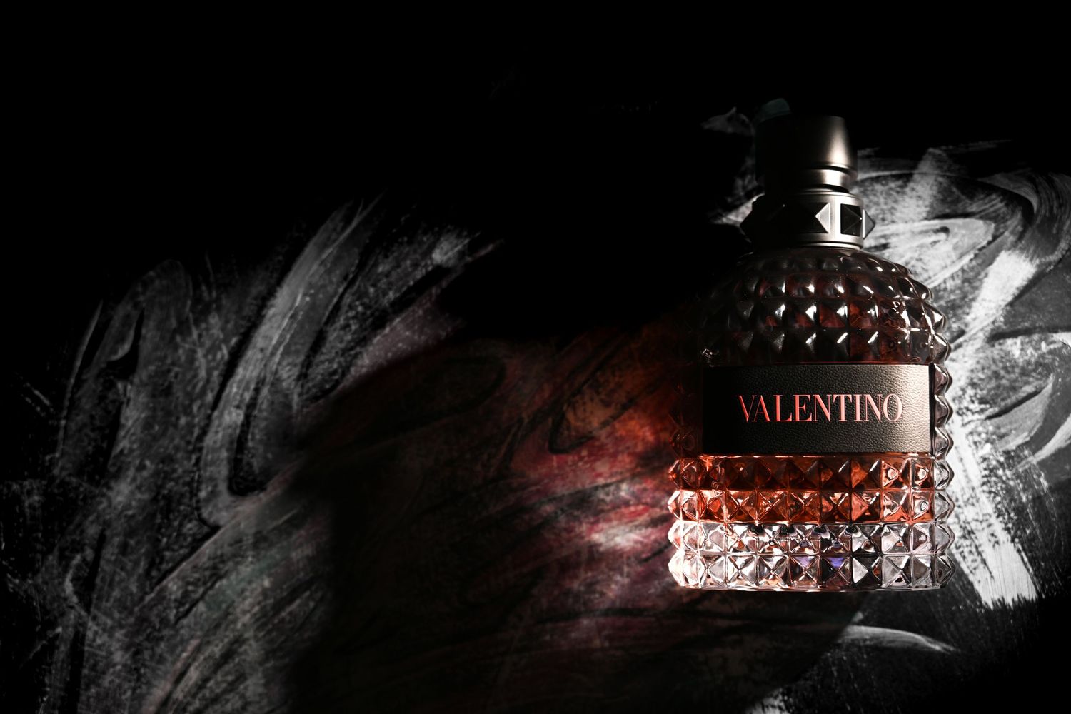 Valentino fragrance bottle photographed with dramatic light and texture for luxury perfume branding.