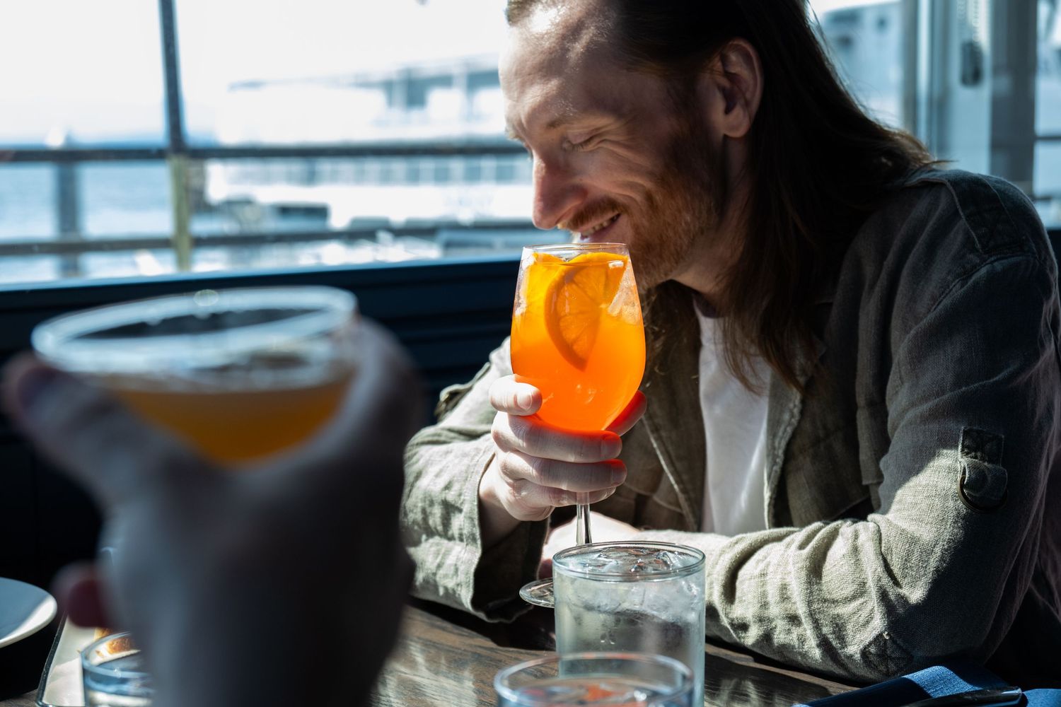 Lifestyle restaurant scene with guest holding cocktail, photographed for hospitality branding and social media use.