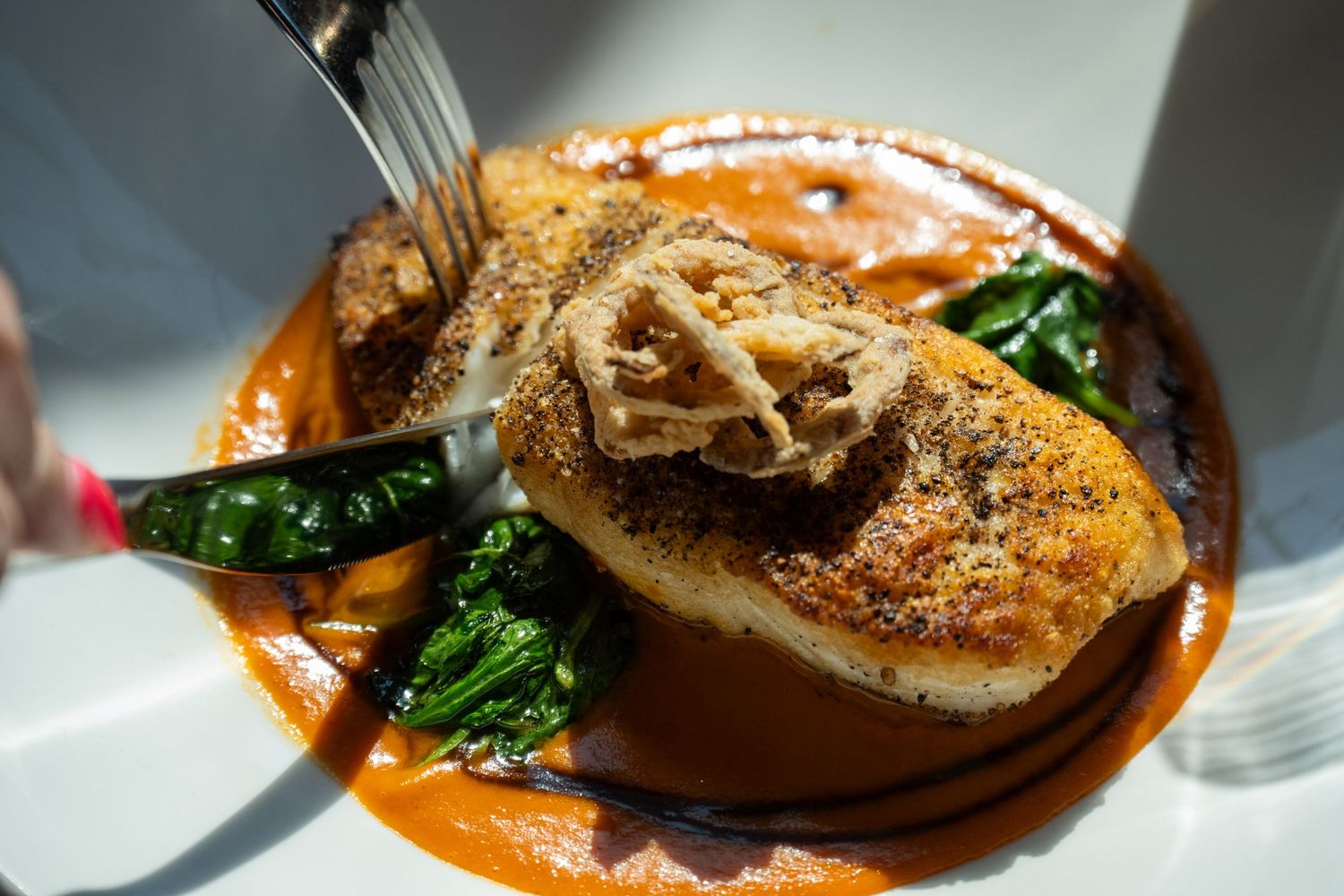 Seared fish with greens and sauce, photographed for restaurant menu and fine dining food photography.