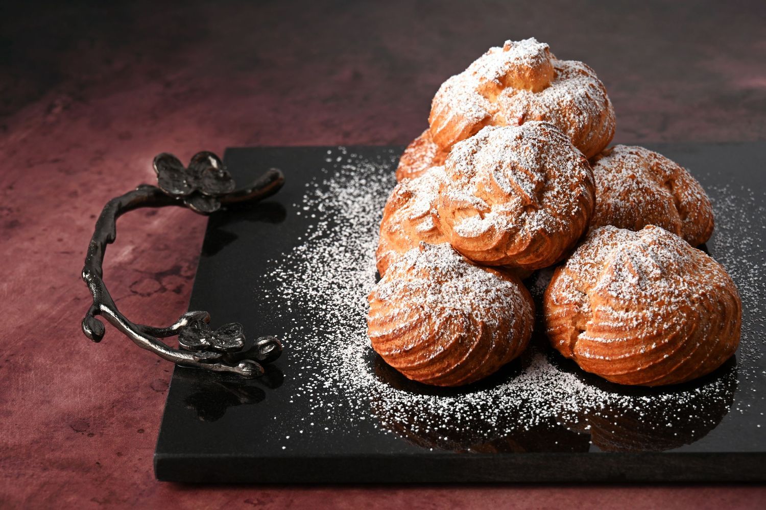Cream puffs dusted with powdered sugar, photographed for bakery menu, dessert branding, and promotional use.