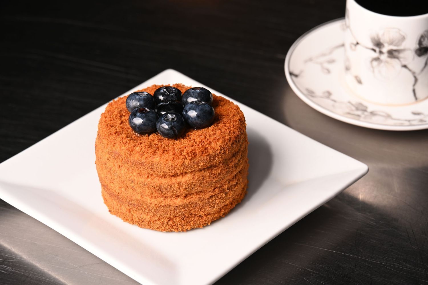 Mini cake topped with blueberries, photographed for bakery menu, dessert branding, and commercial food photography.