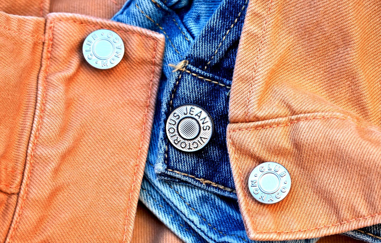 Close-up of denim jacket buttons and stitching, photographed for apparel detail and lifestyle product branding.