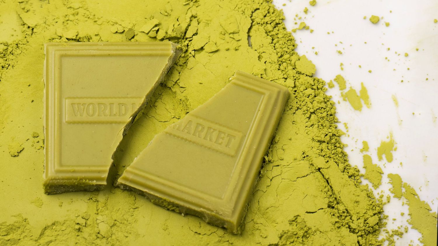 Matcha chocolate pieces styled with powdered matcha, photographed for artisanal food and product branding.