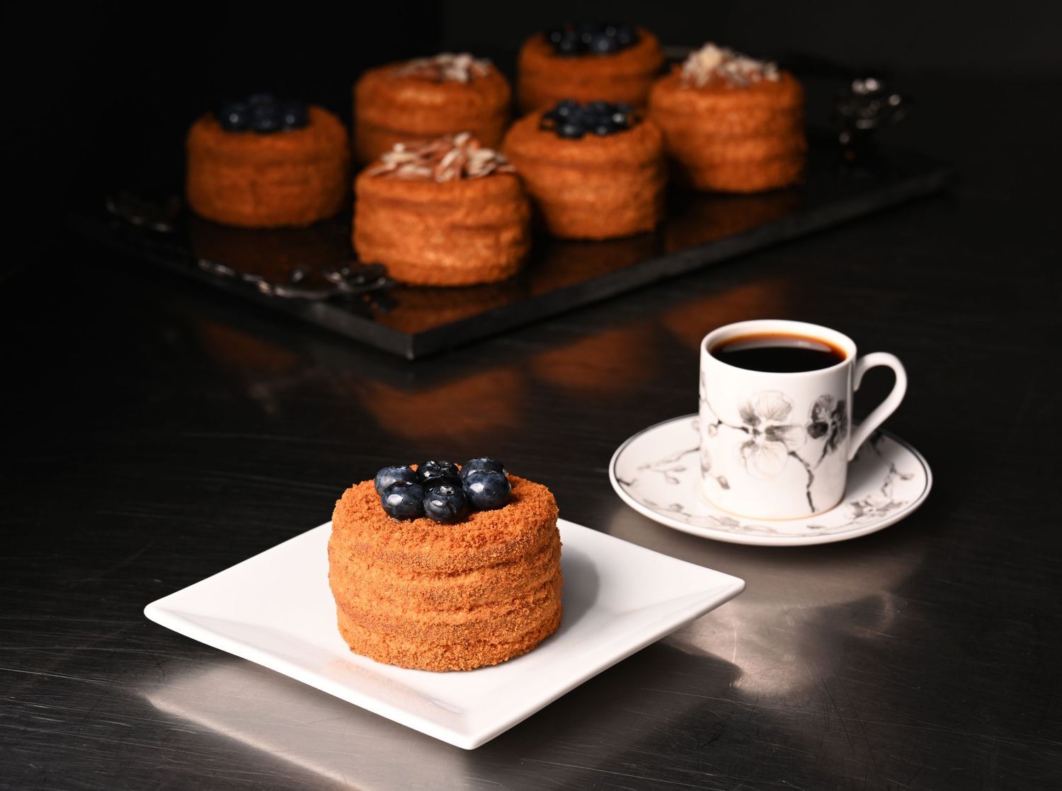 Mini cakes served with coffee, photographed for bakery menus, café branding, and commercial food photography.