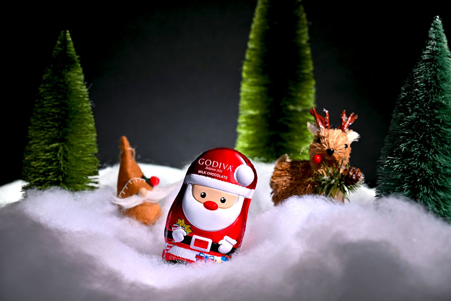 Godiva Santa milk chocolate styled in festive winter scene, photographed for holiday product and seasonal marketing.