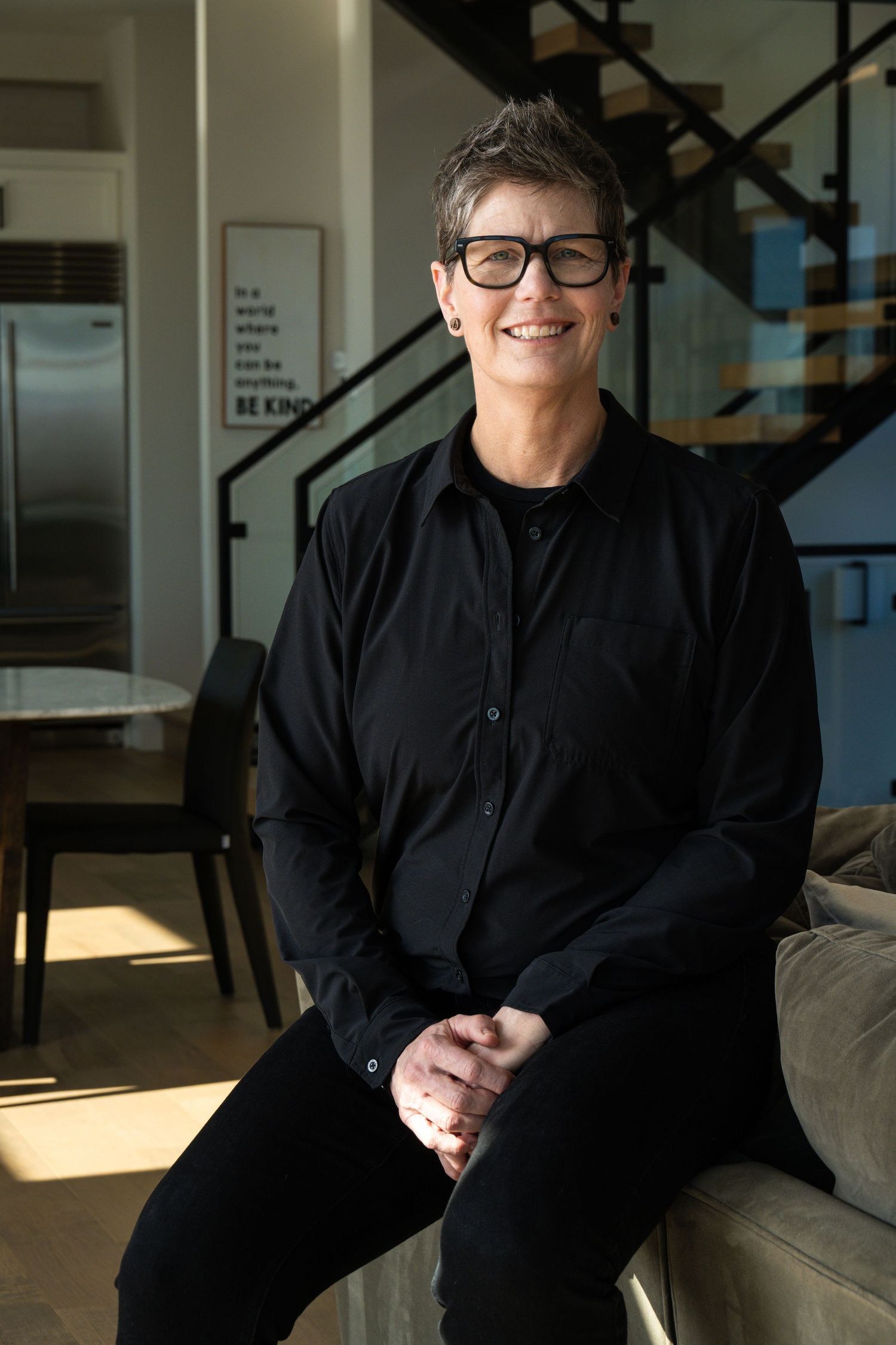 Professional headshot of woman in modern interior, photographed with soft natural light for personal branding and business use.