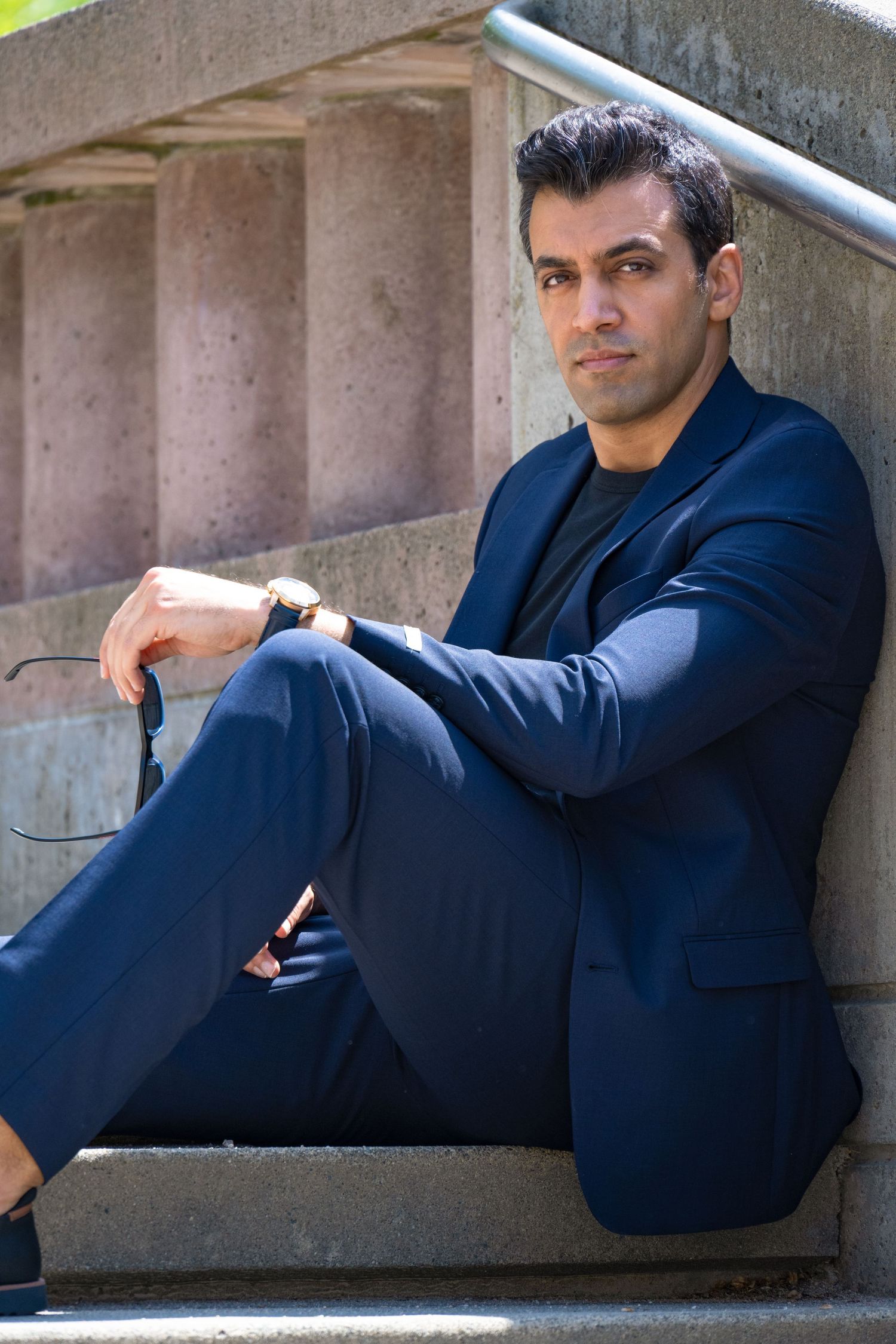 Professional portrait of man in navy suit outdoors, photographed for executive branding and modern business headshots.