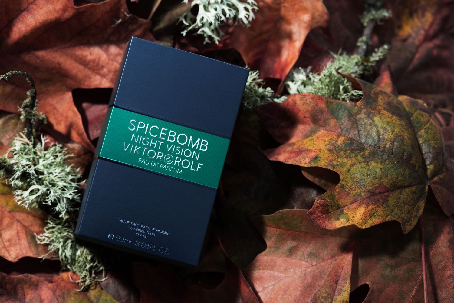 Spicebomb Night Vision fragrance box styled with autumn leaves, photographed for luxury fragrance advertising.