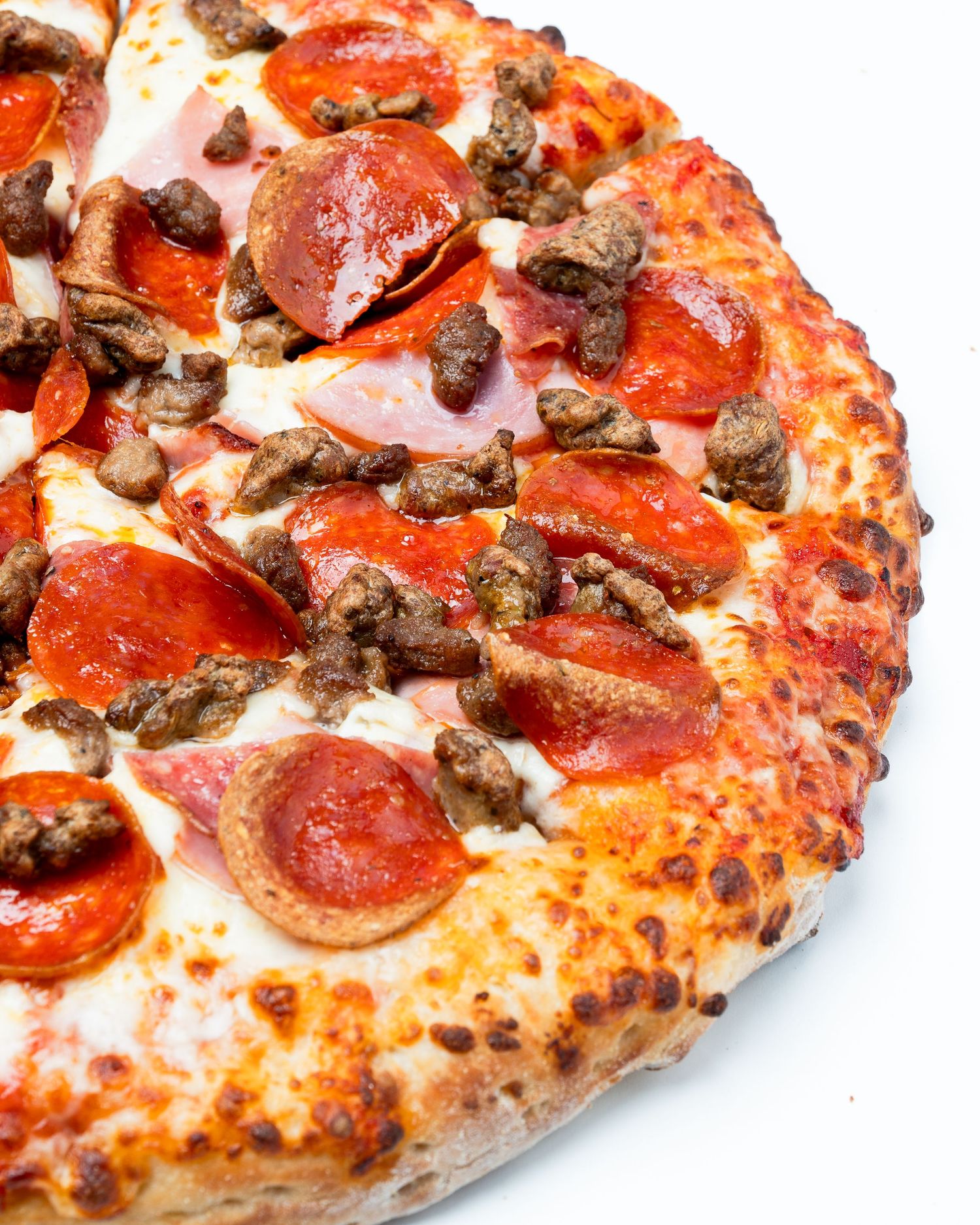 Crispy crust pizza with pepperoni, ham and sausage isolated on light background for menu and restaurant branding.
