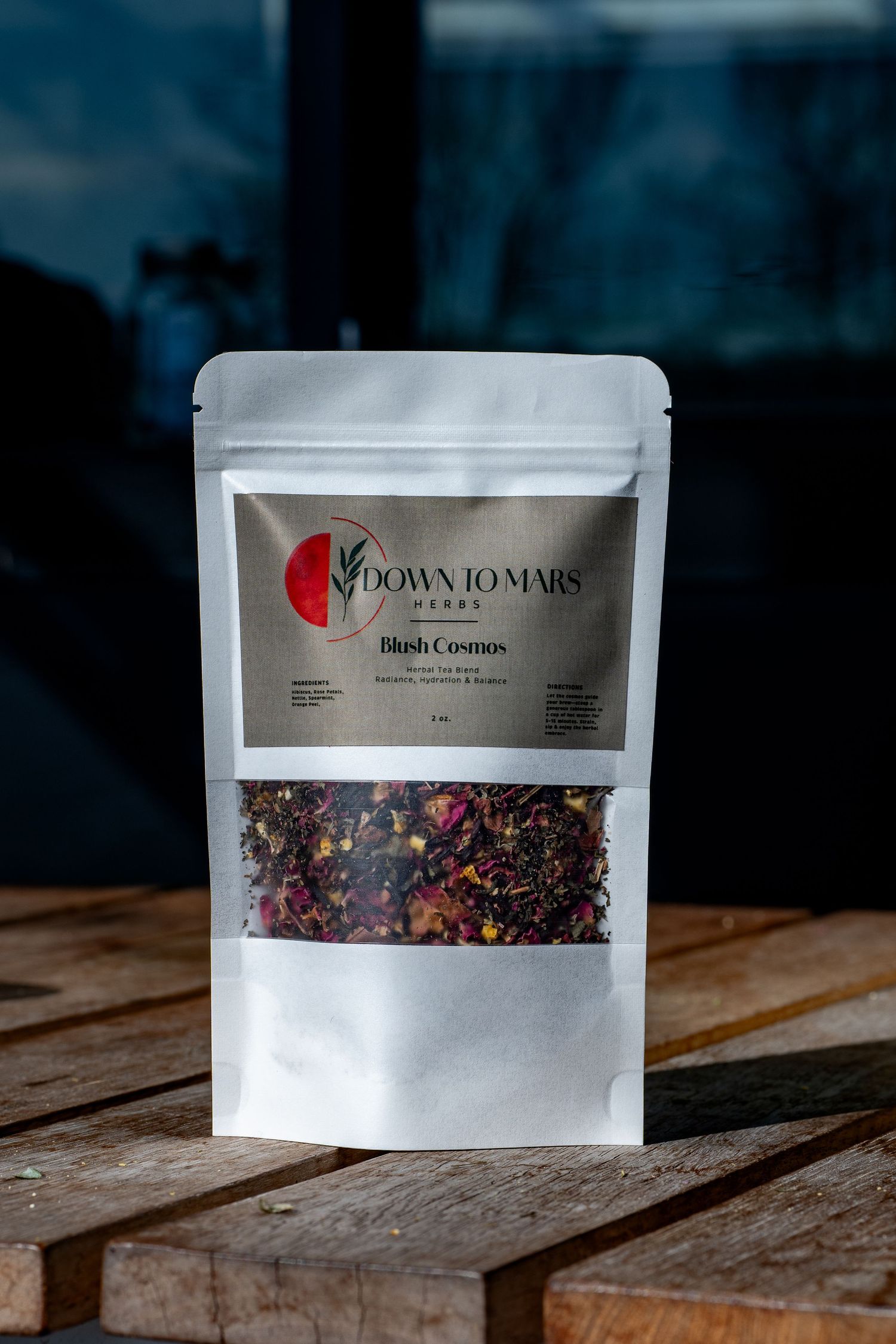 Loose leaf herbal tea in branded packaging photographed on rustic wood with soft shadows and natural tones.