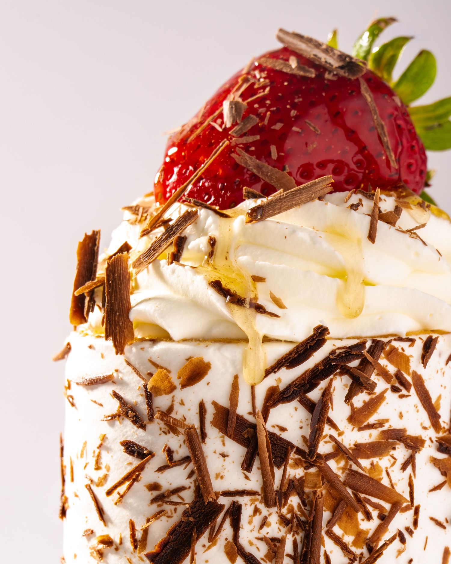Strawberry dessert with cream and chocolate shavings, photographed for dessert branding and commercial food use.