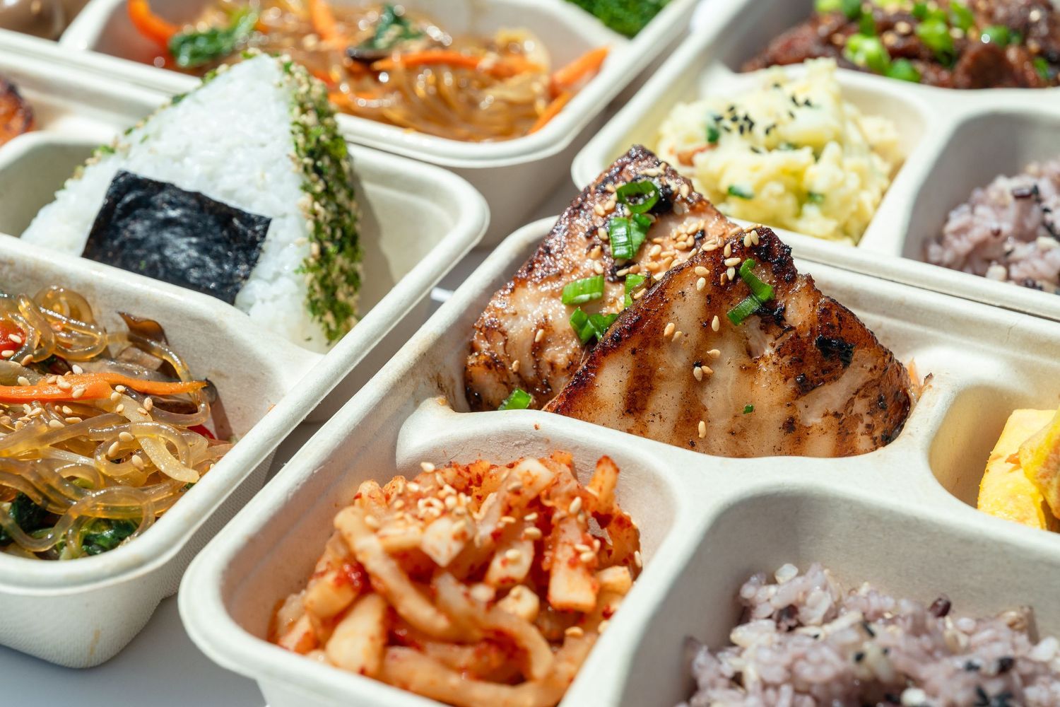 Korean bento box with grilled protein, rice, and sides, photographed for restaurant menu and delivery platforms.
