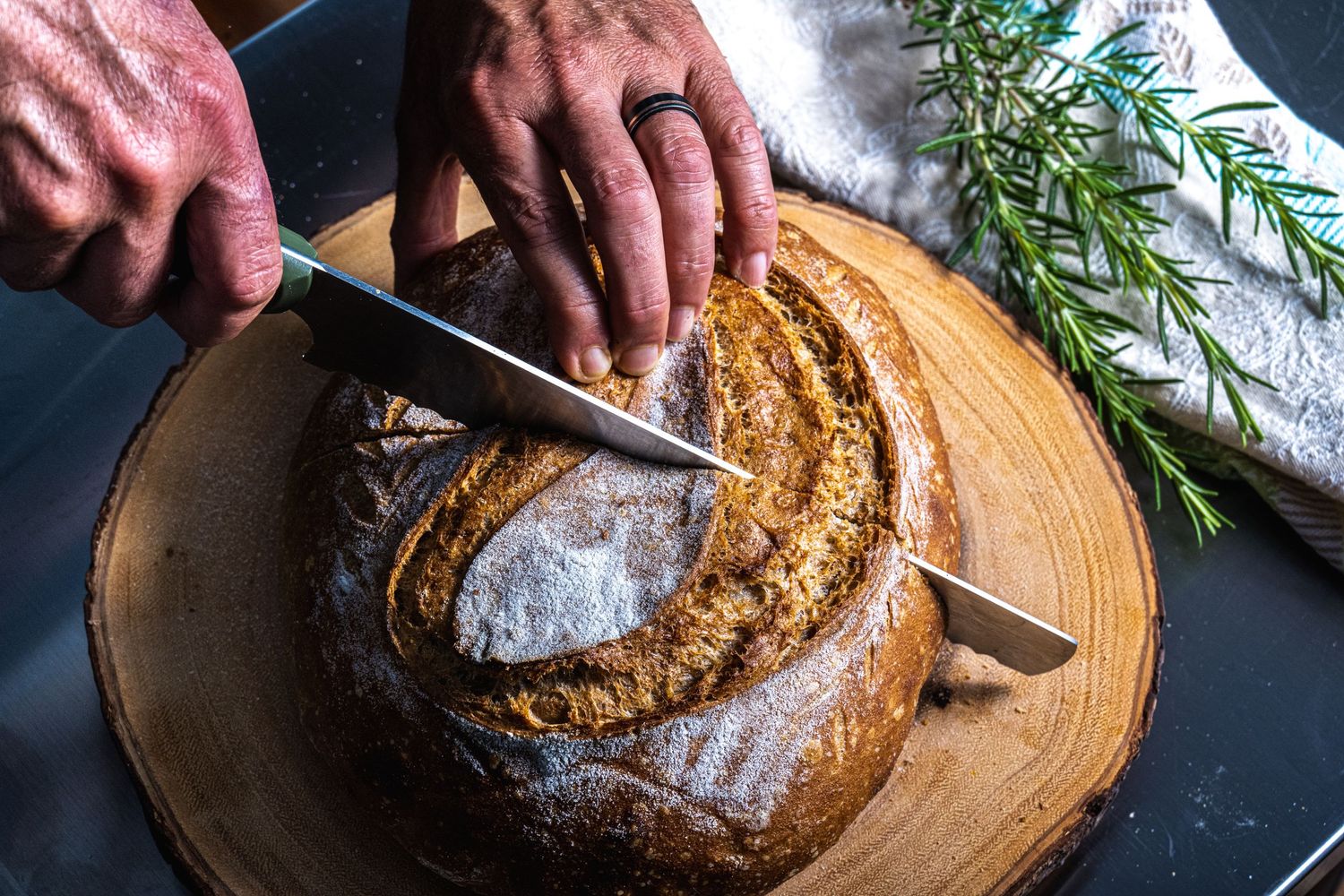 Rustic sourdough bread being sliced, photographed for bakery branding and artisan food photography.