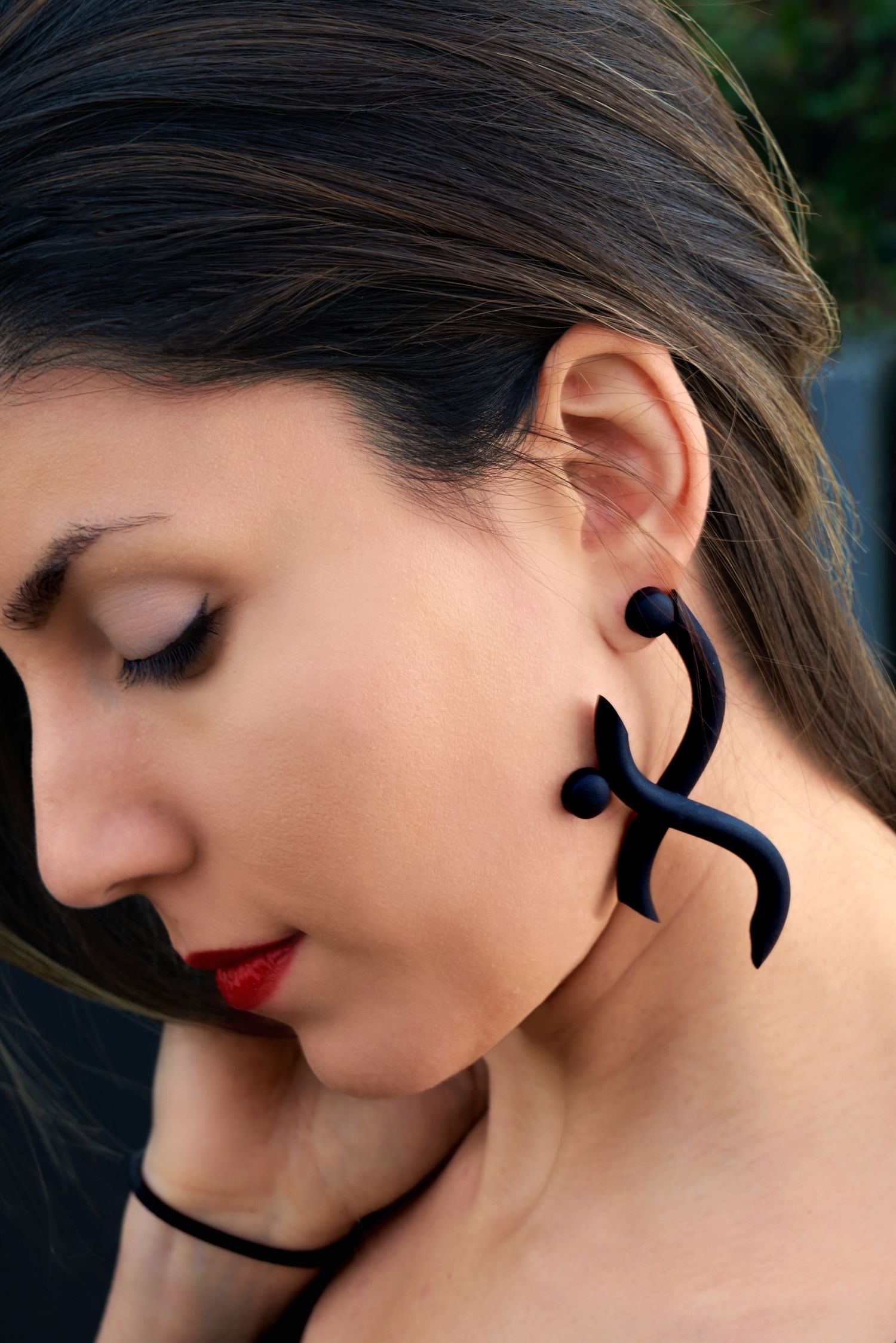 Sculptural black statement earrings worn by model, photographed for jewelry and fashion product branding.