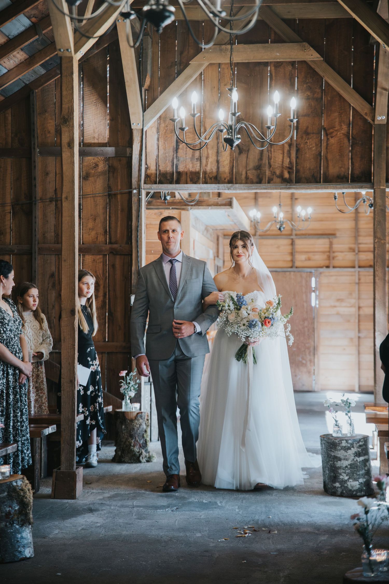 Father walking the bride down the aisle inside the barn at Estate 248 under vintage chandeliers