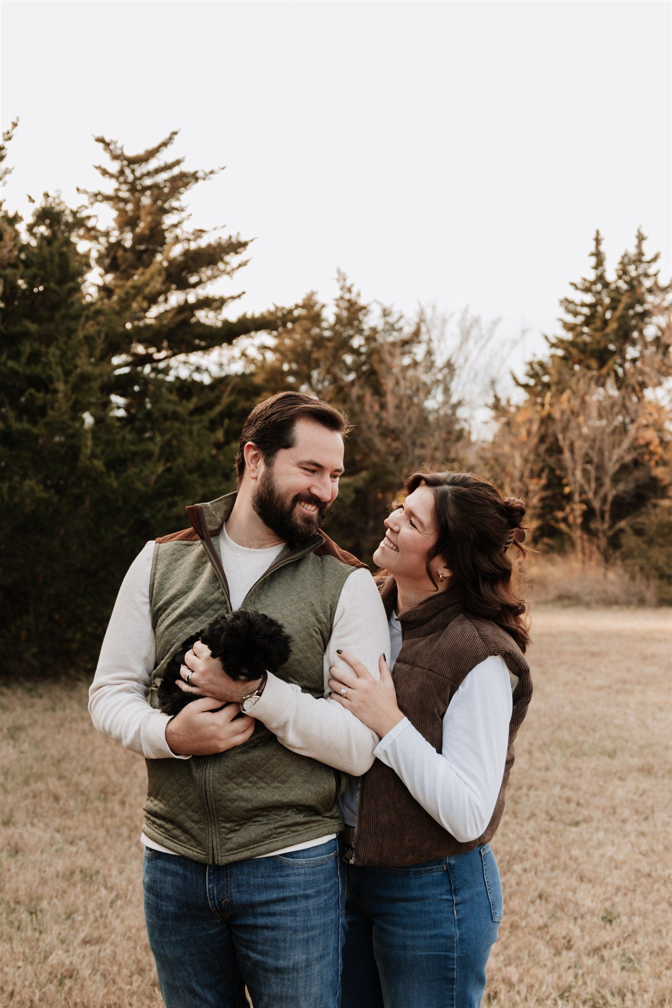 Couple laughing together during casual outdoor autumn photo session.
