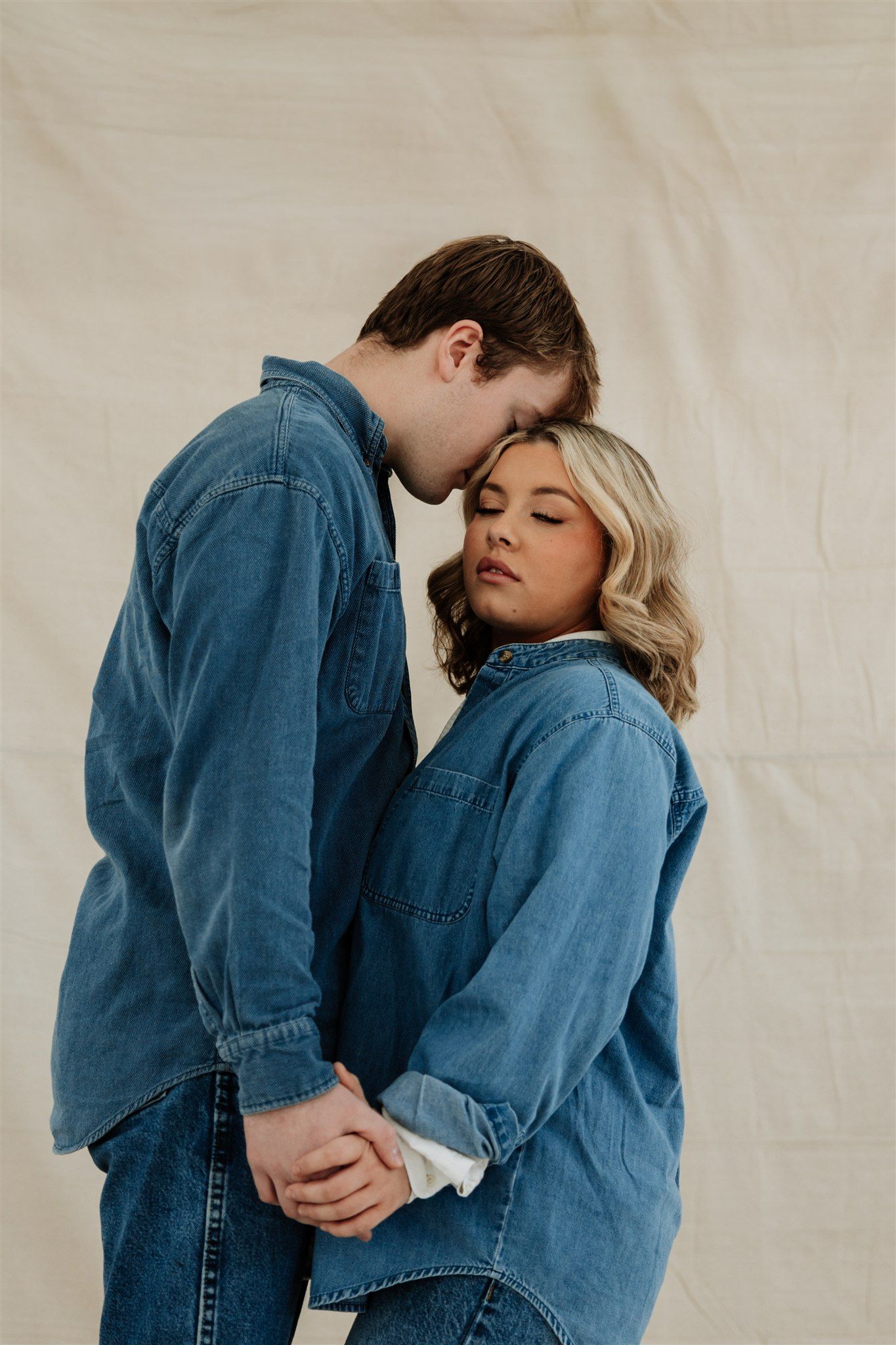 Romantic couple in matching denim embracing in intimate portrait series.