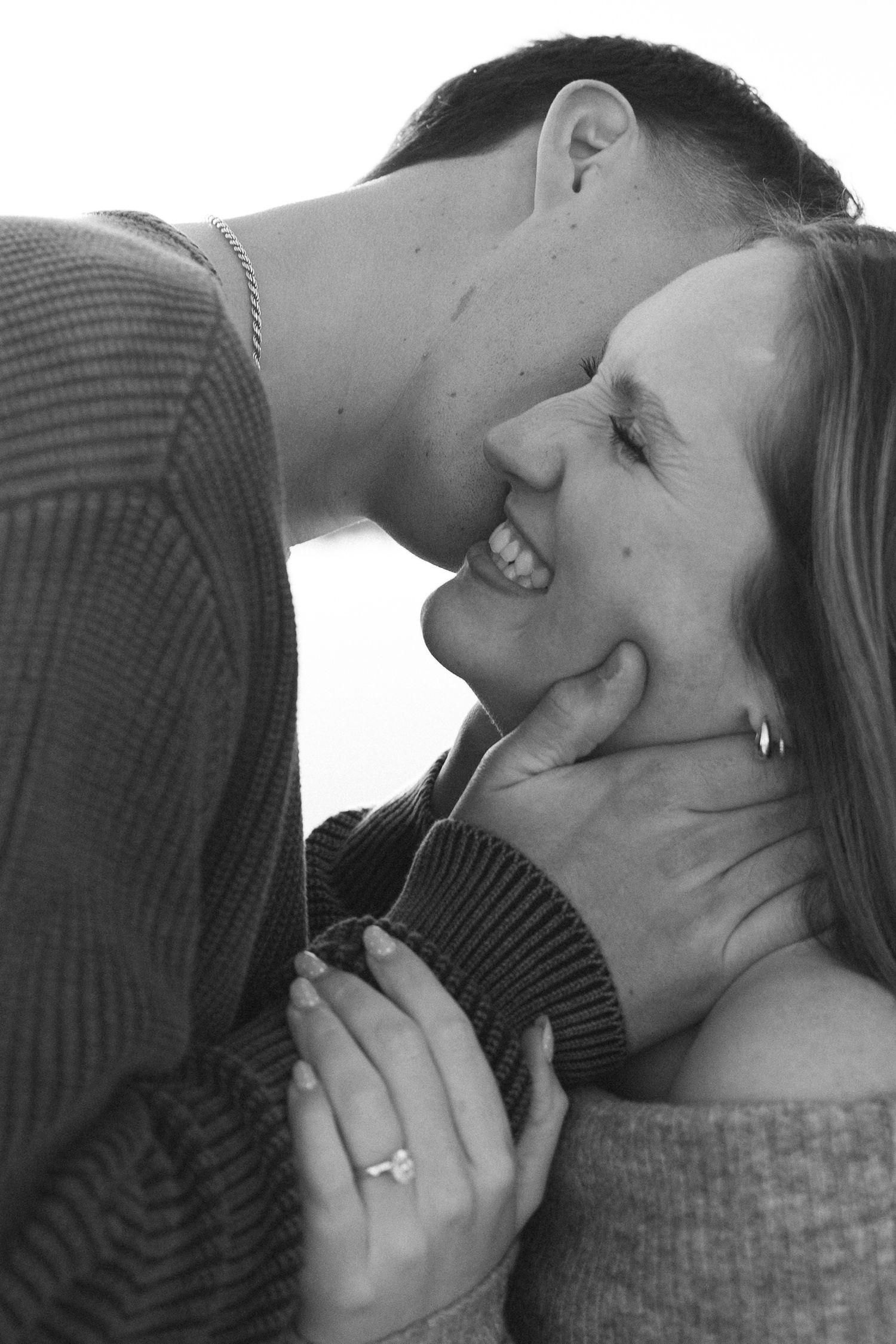 An intimate black and white portrait of a couple sharing a romantic moment.