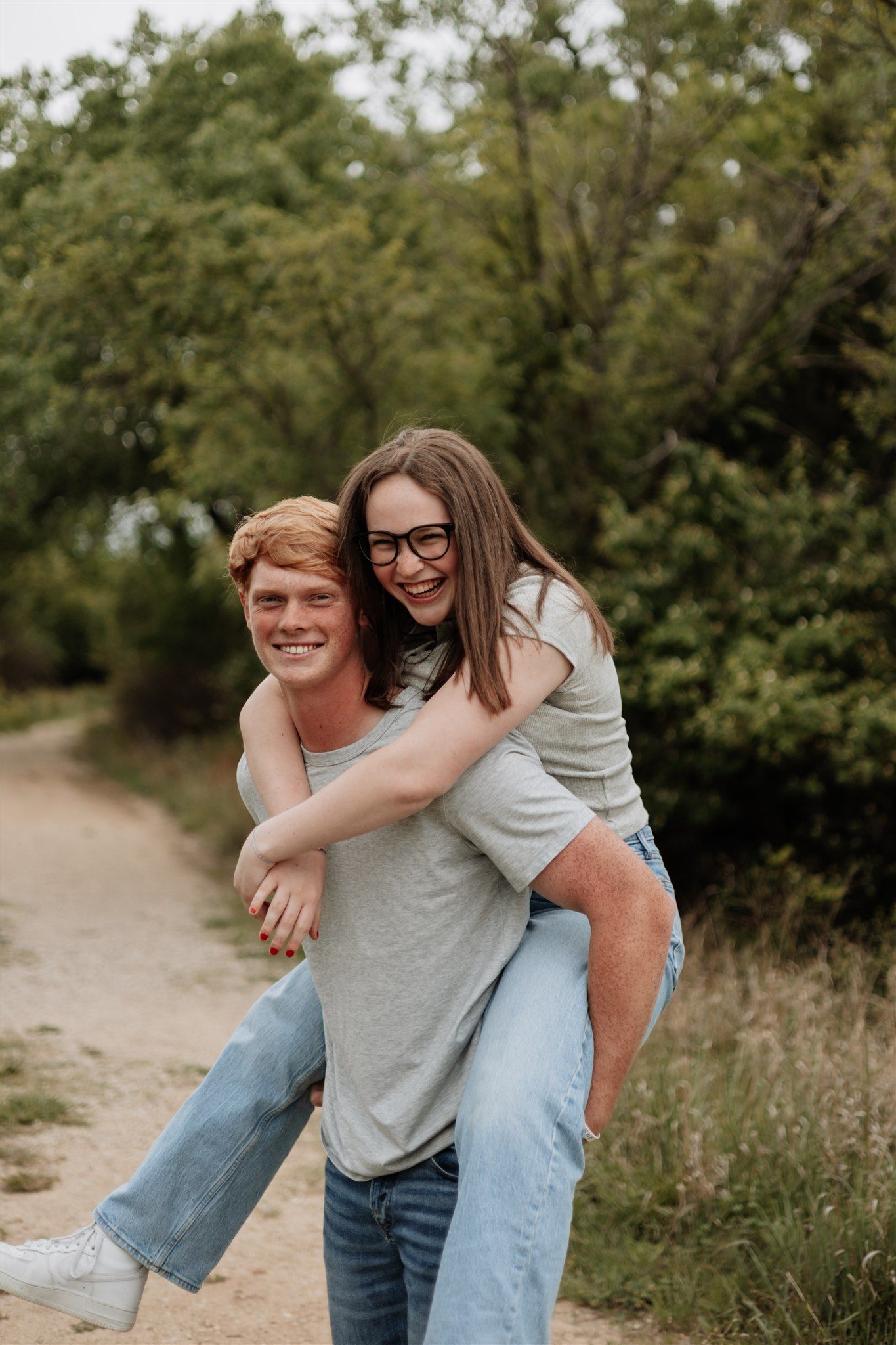 Playful piggyback ride moment captured in natural outdoor setting.