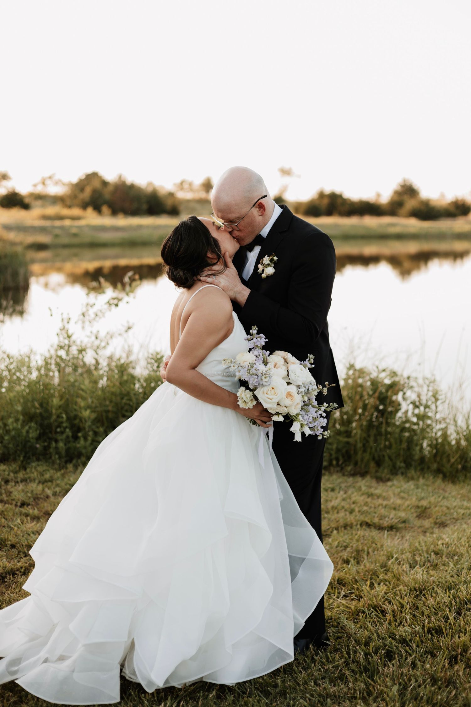 Romantic wedding photos by a lake with flowing white ballgown dress.