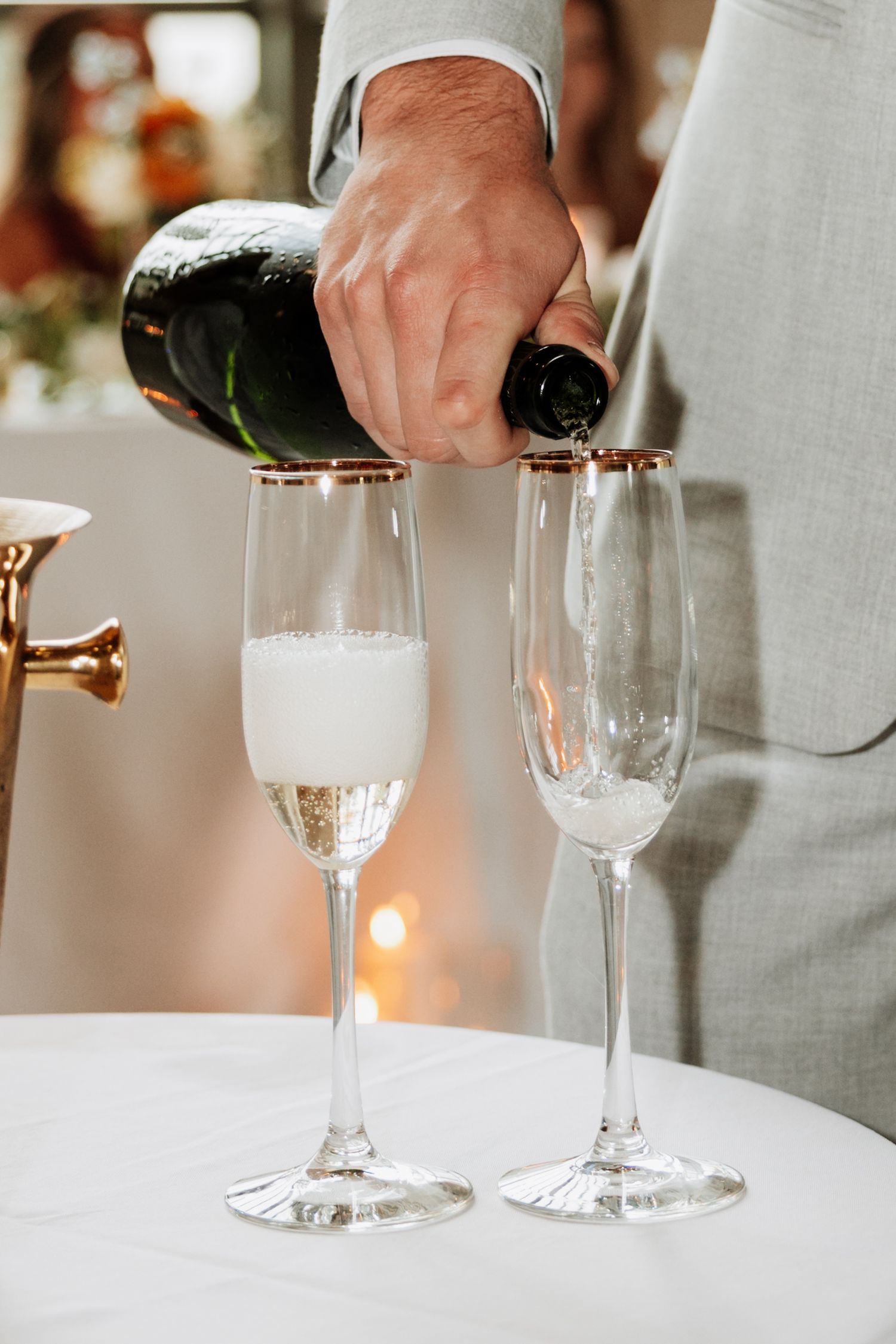 Champagne being poured into elegant crystal flutes at wedding reception.