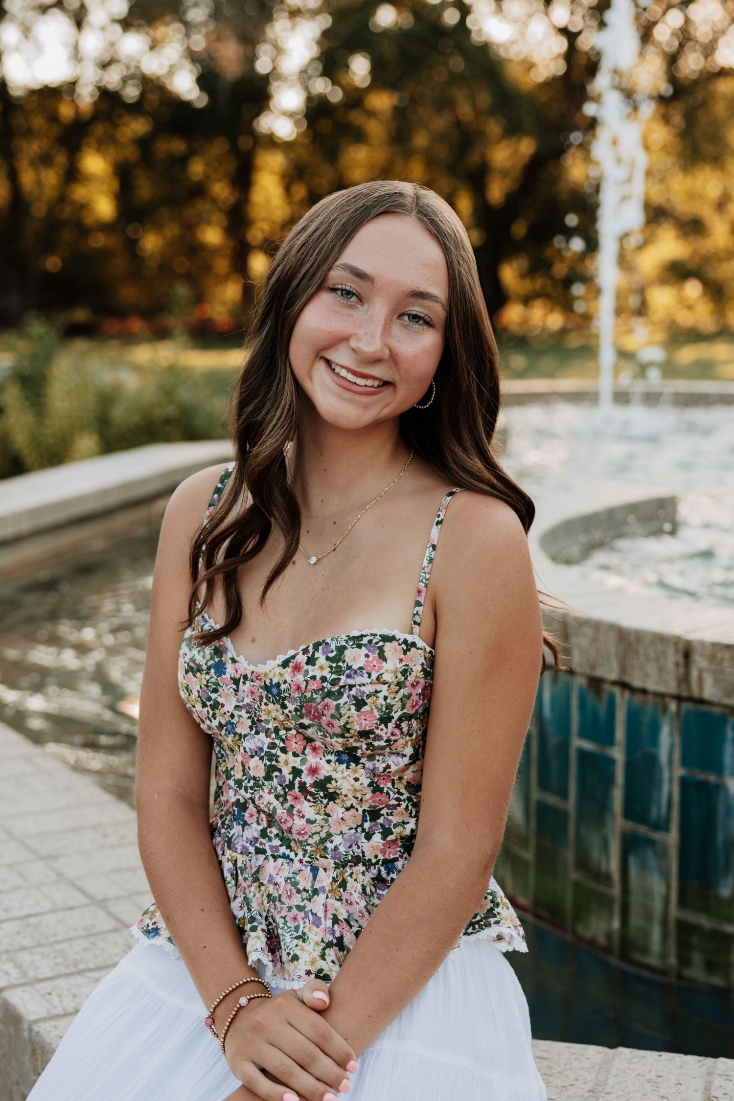 Portrait series by pool wearing floral summer dress at sunset.