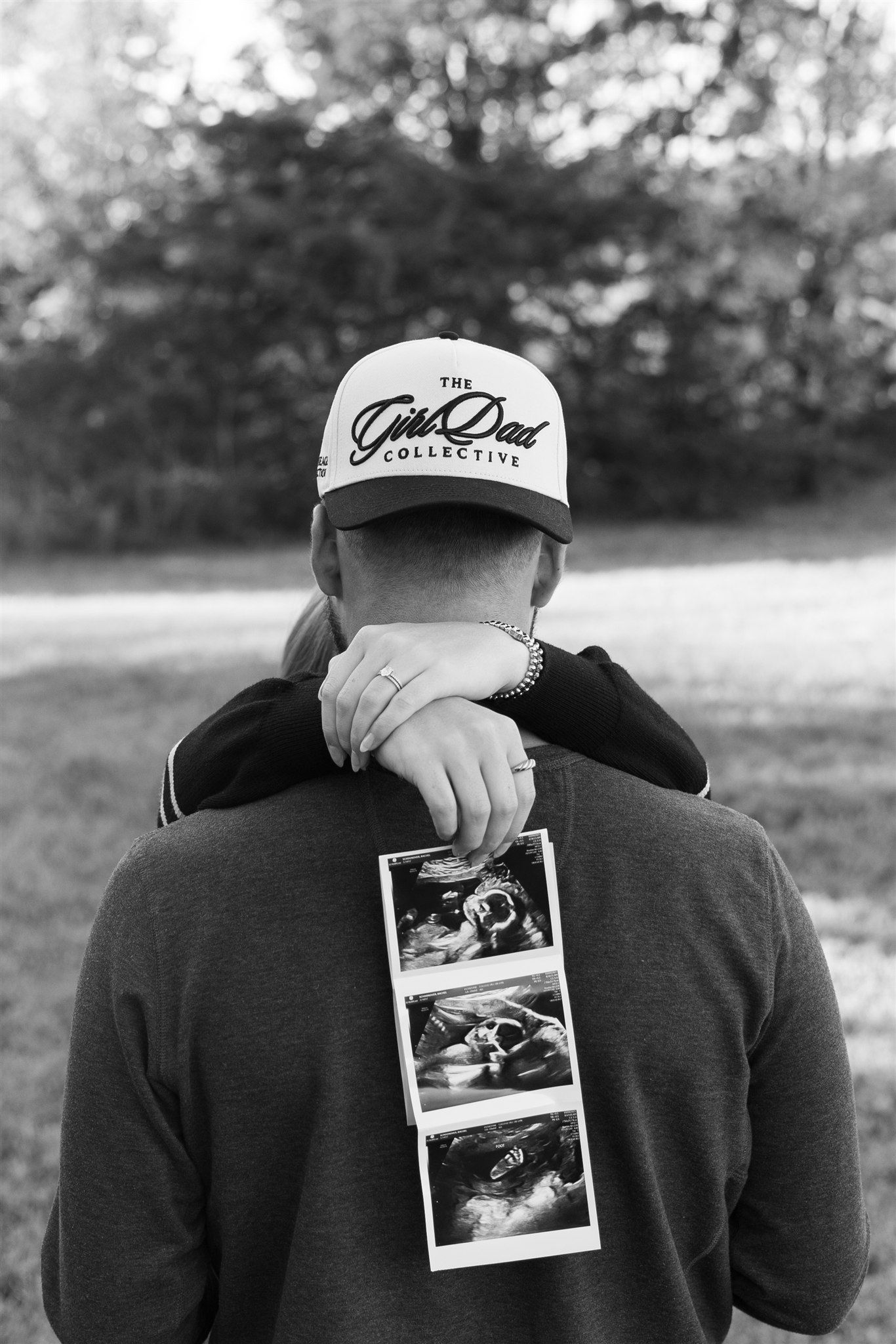 Series of black and white photos showing someone holding polaroid pictures outdoors.