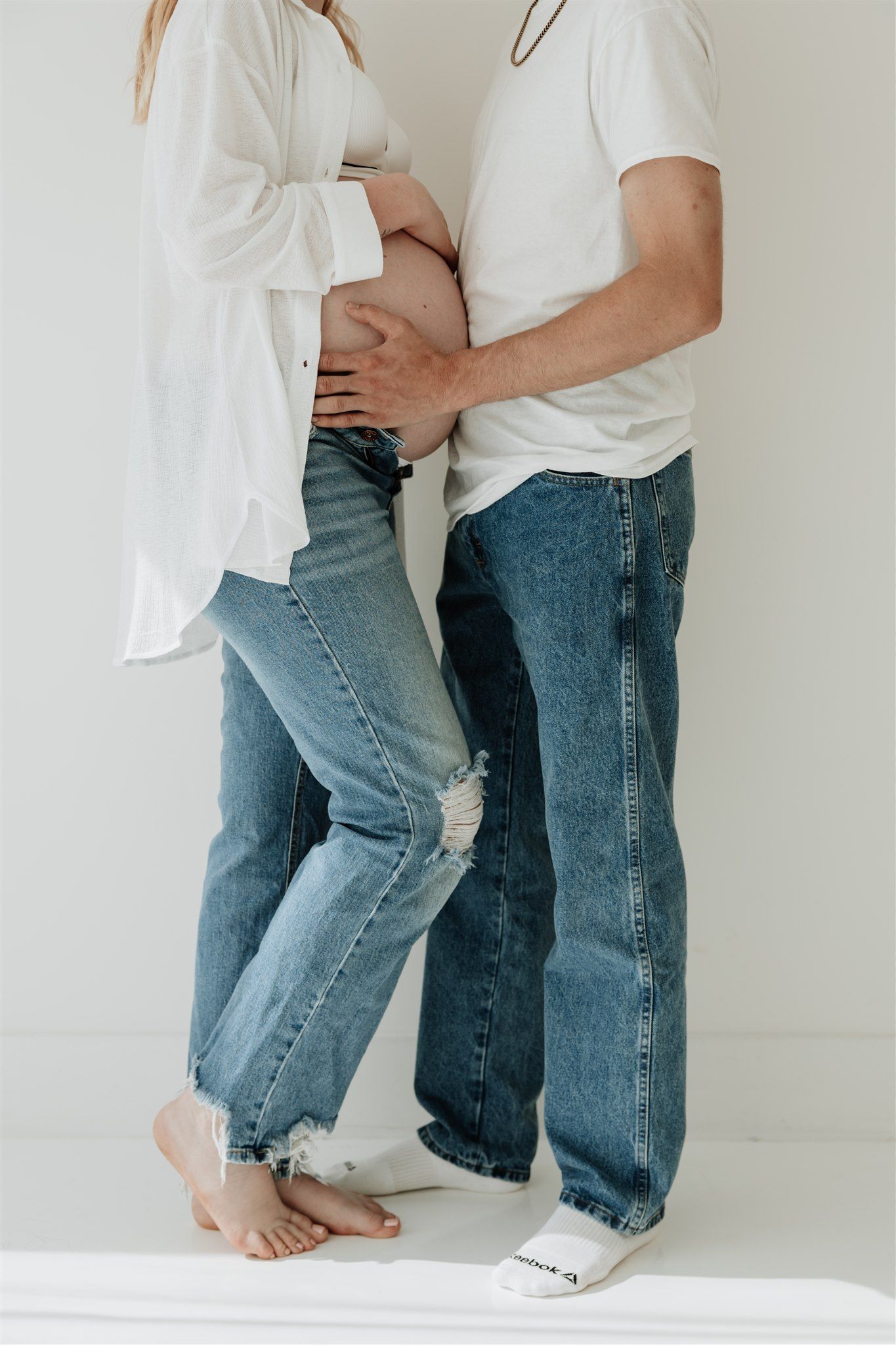 Close-up shots of legs wearing blue jeans and white clothing against a white background.