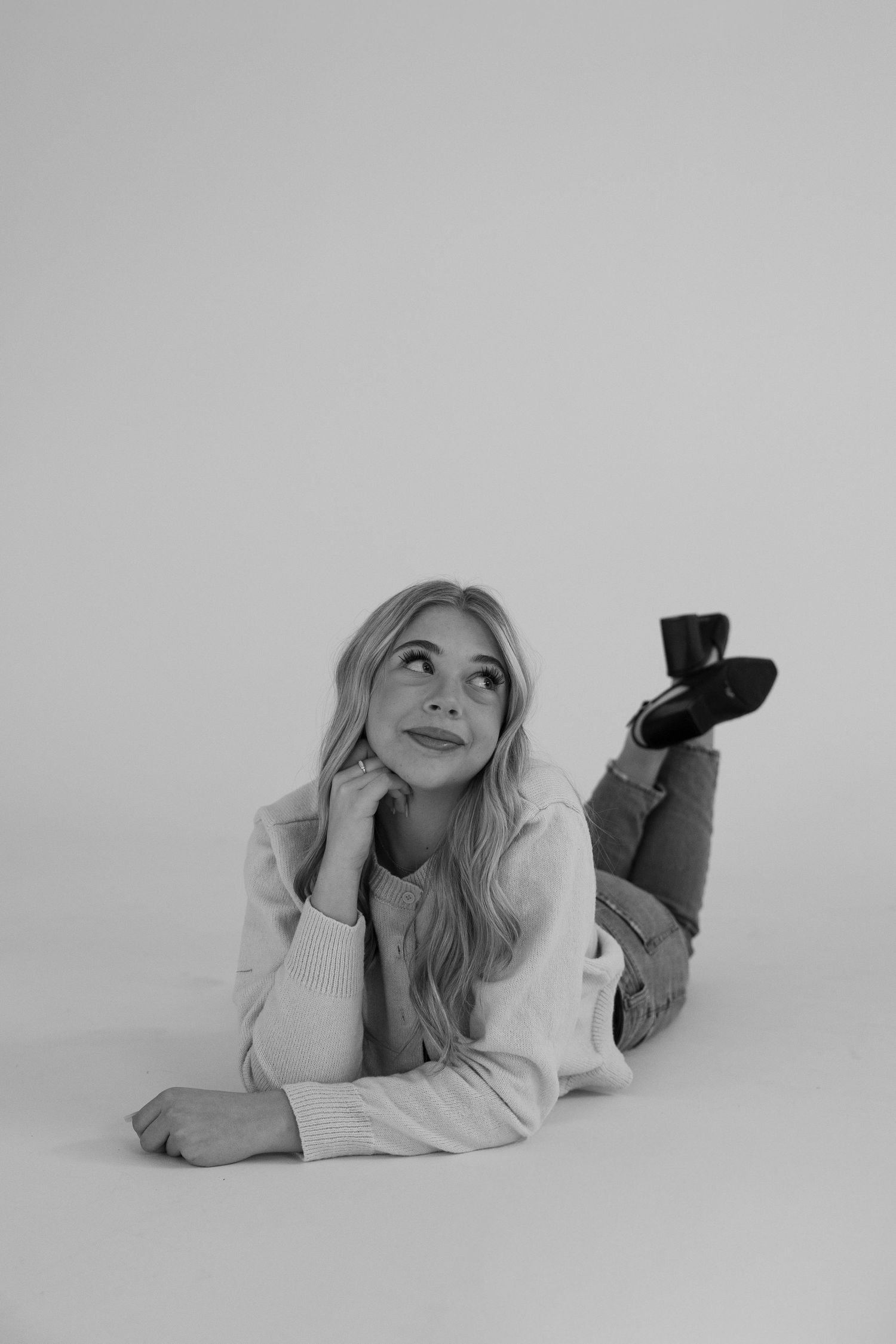 Black and white portrait series showing relaxed poses against a light background.