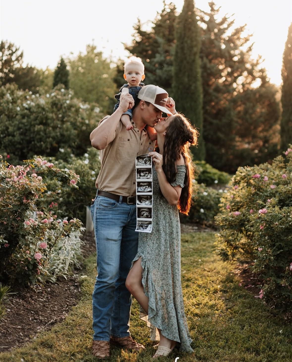 Couple sharing romantic moment in garden setting during golden hour.