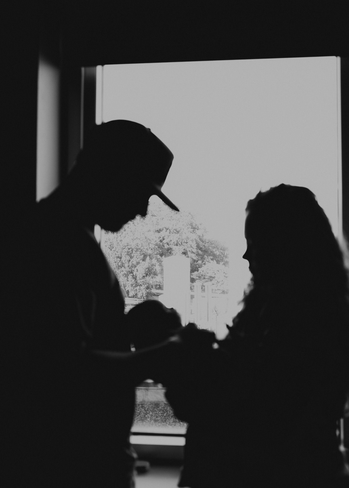 A sequence of silhouettes in black and white showing a couple embracing in a romantic scene.