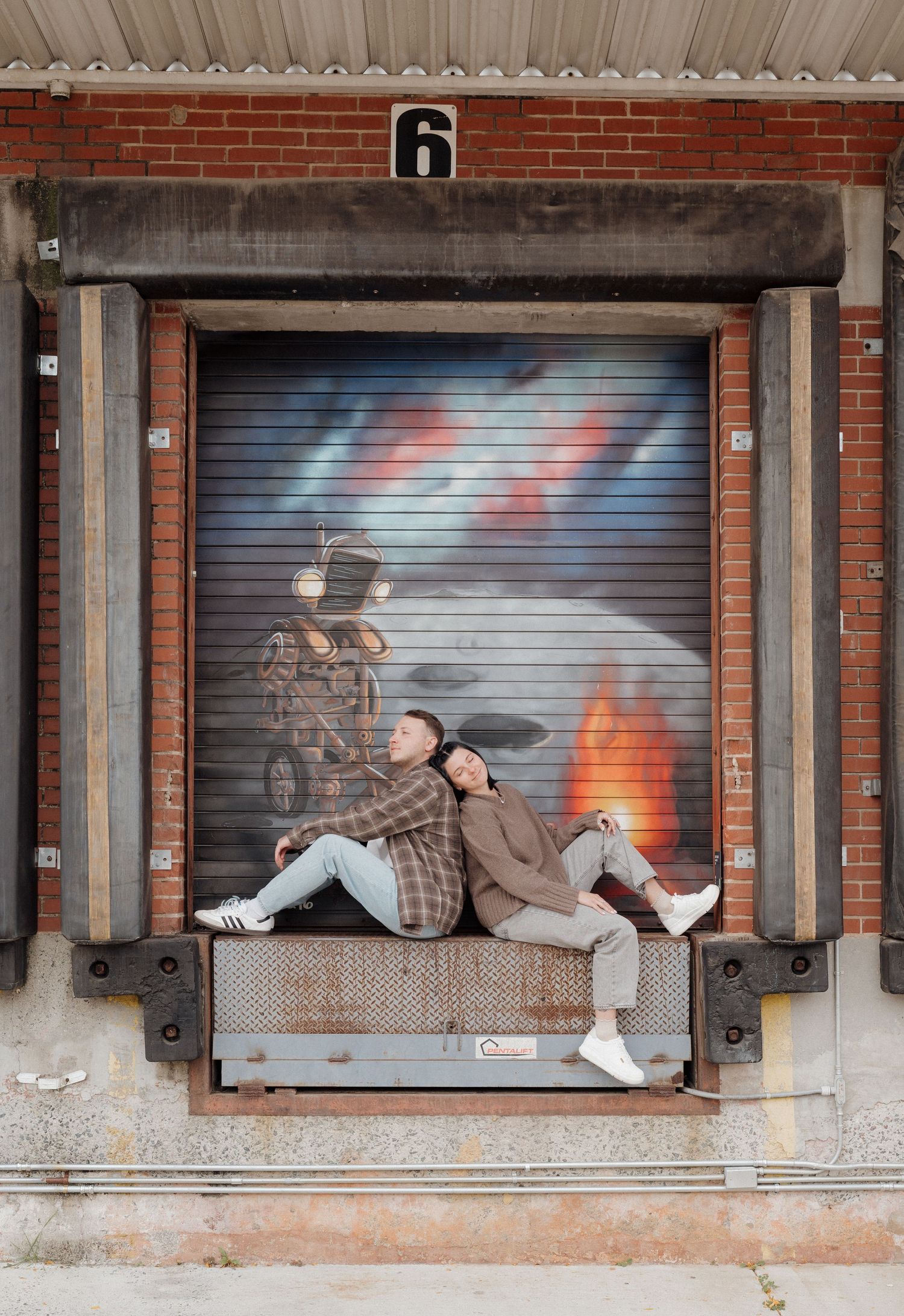 A sequence of photos shows someone reclining on a concrete loading dock ledge against a brick wall with metal shutters.