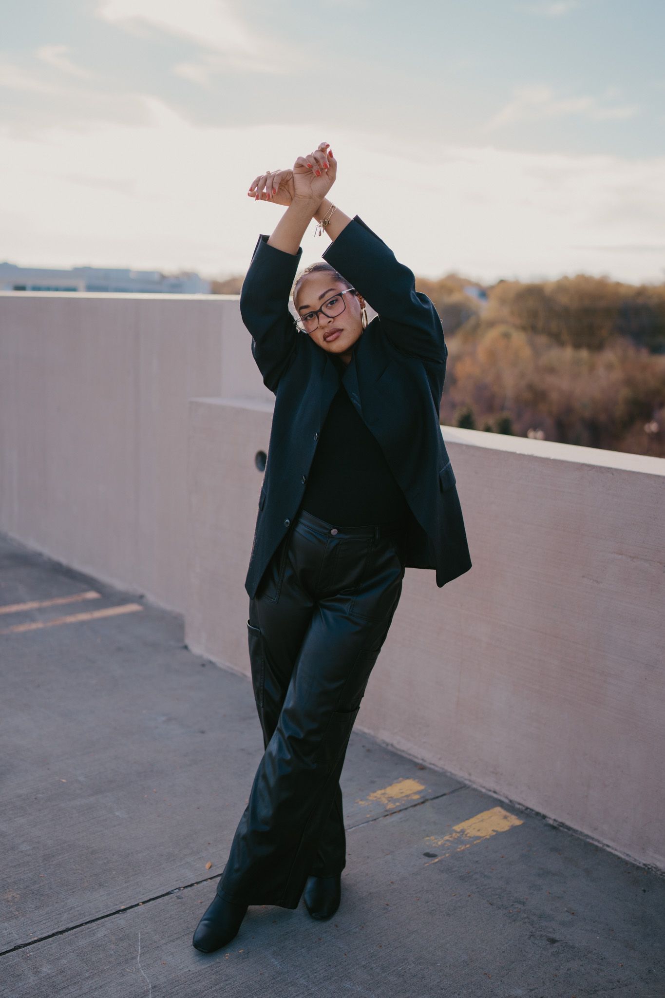A person in dark clothing dances expressively against a concrete wall in a series of dynamic movement poses.