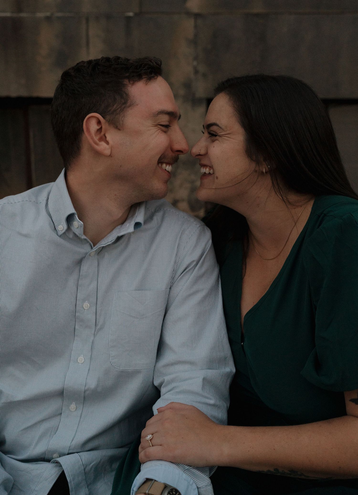 A couple shares an intimate moment together in a dimly lit setting wearing casual attire.