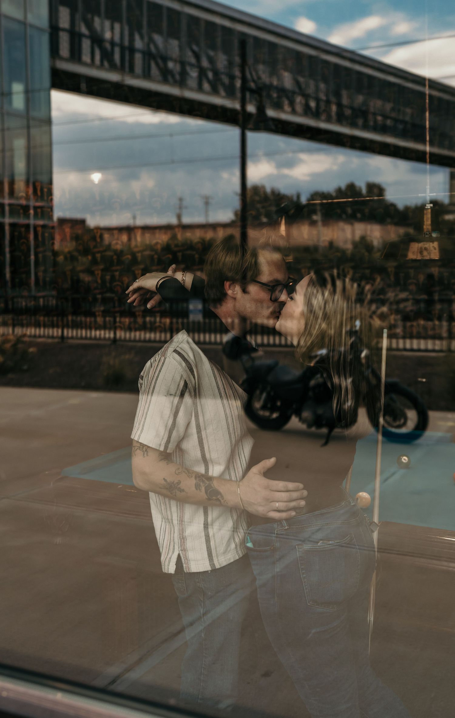 A series of reflective window panels showing a person in motion against an urban backdrop at dusk.