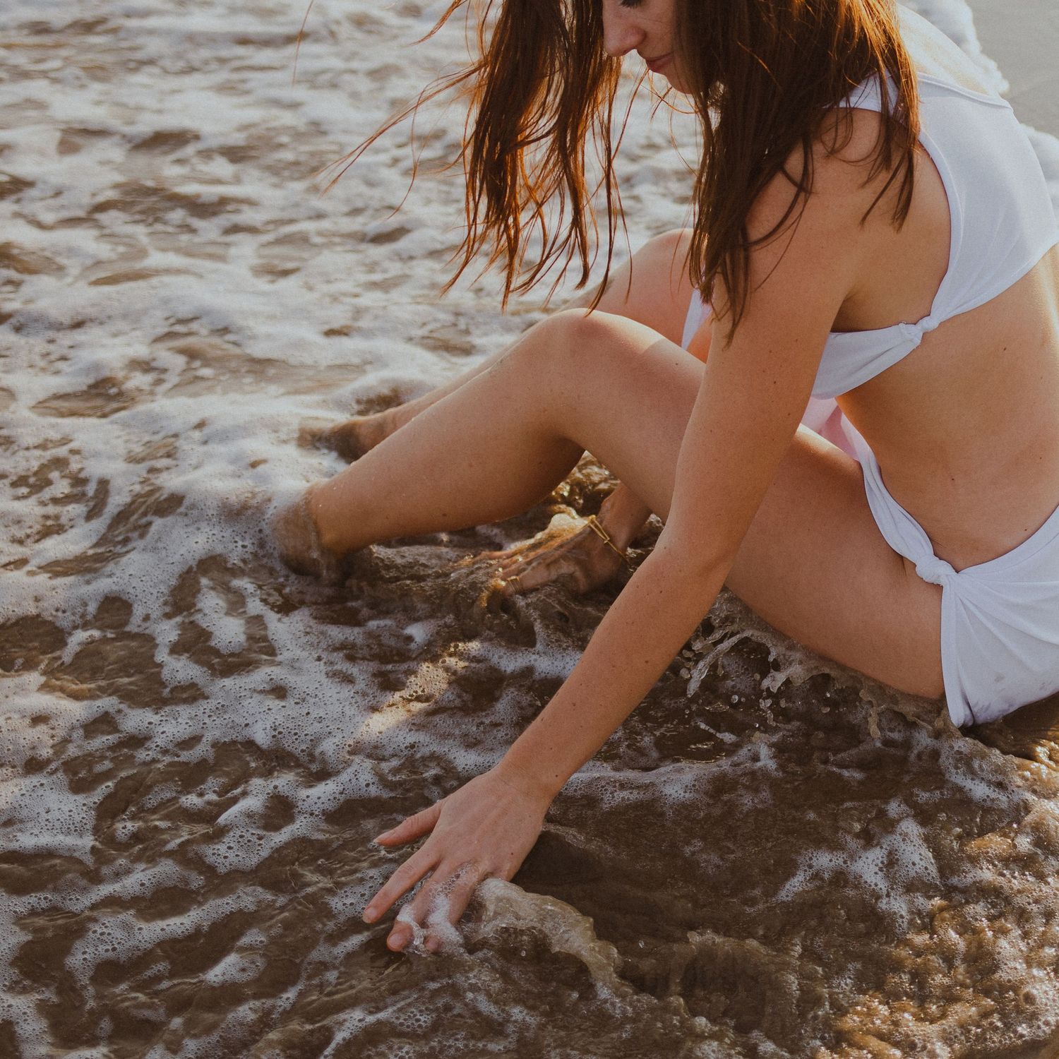 Une jeune fille se tient au bord de la mer