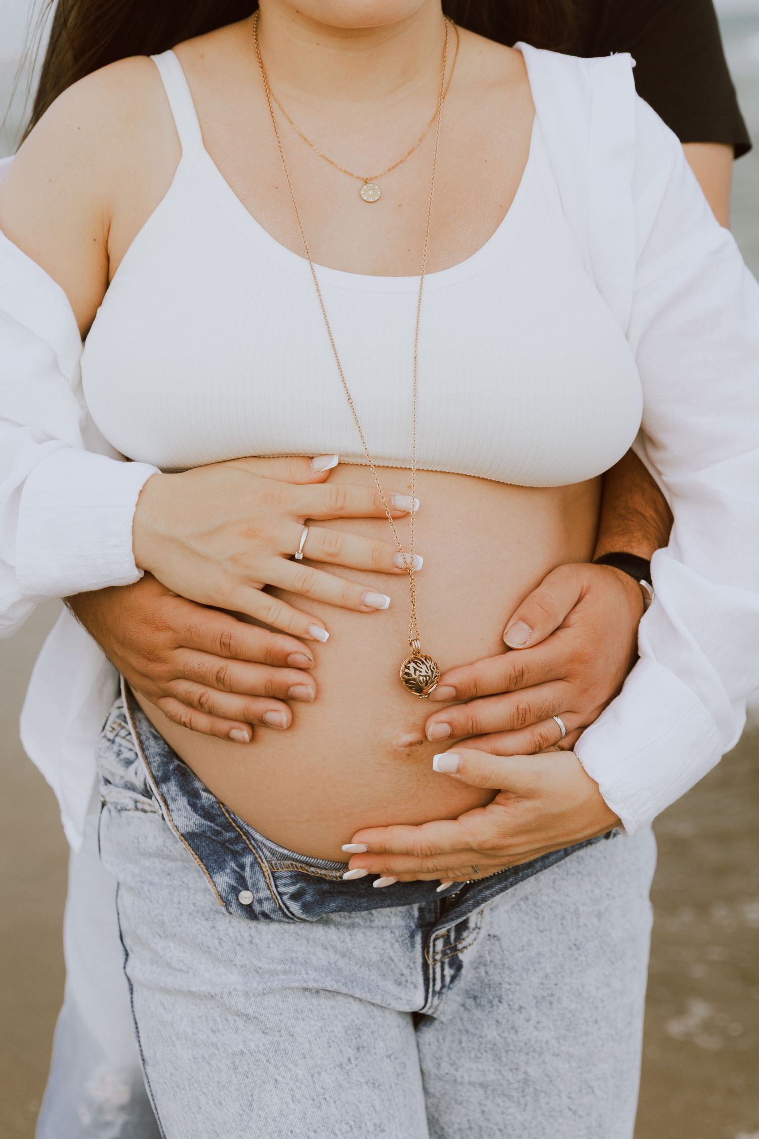Photo d'un ventre de femme enceinte, le papa et la maman tiennent le ventre avec amour.