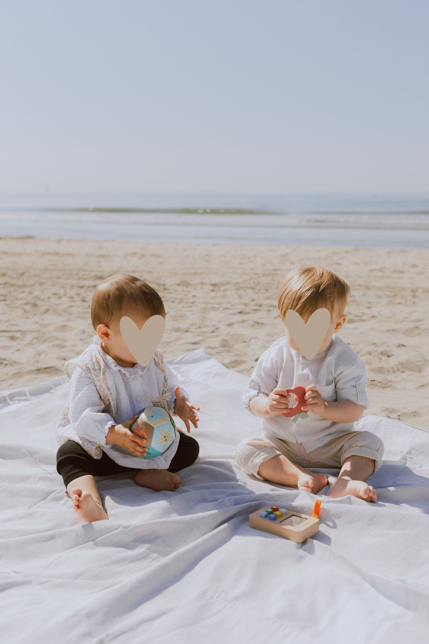 Deux bébés jouent ensemble à la plage de Montpellier pendant une séance photo en famille.