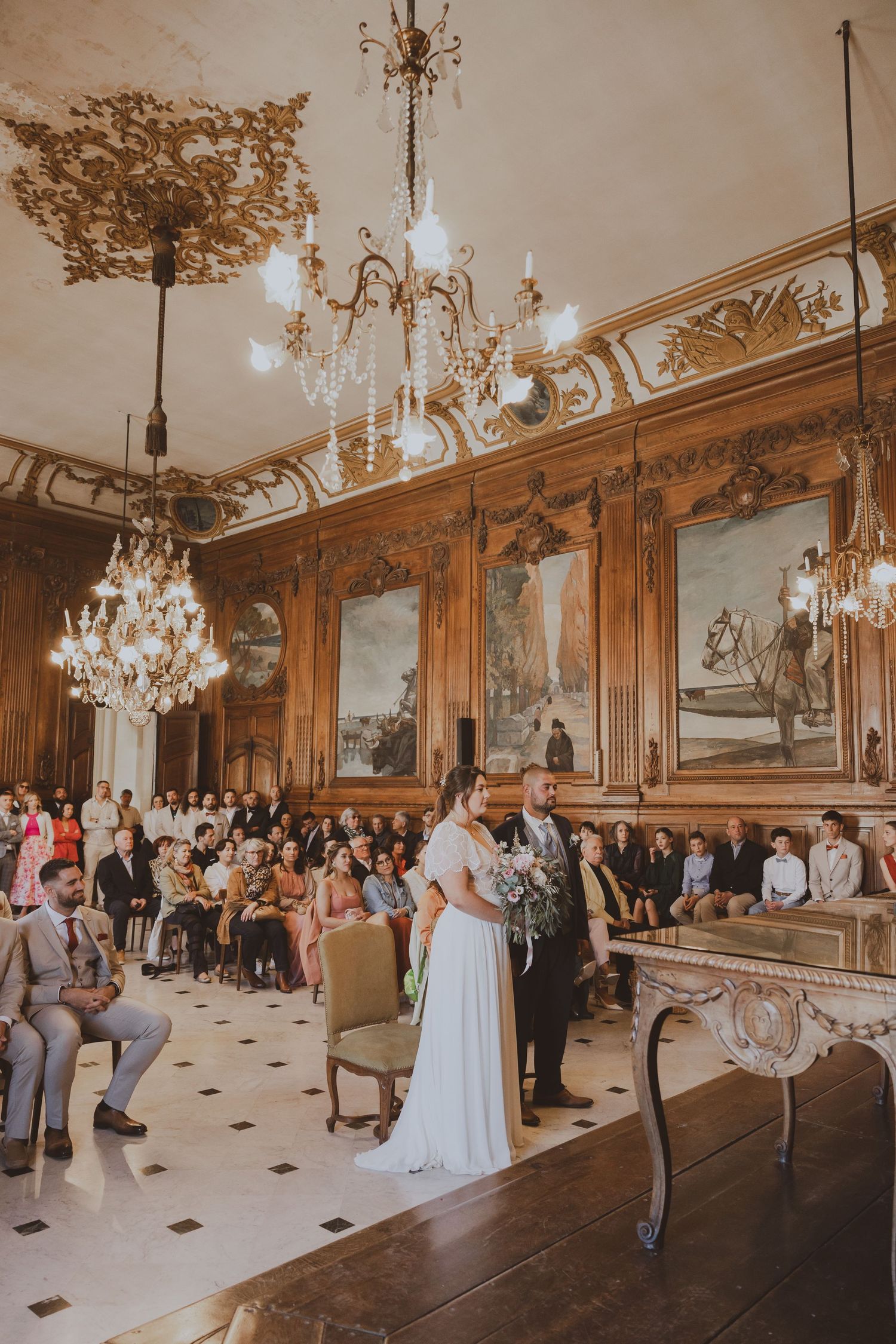 Une cérémonie de mariage élégante dans une salle de bal classique et bien décorée.