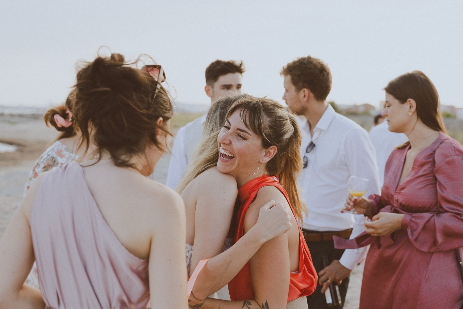 Des amis rigolent pendant la séance photo de groupe. Photo par Alice Enrico, photographe mariage à Montpellier.