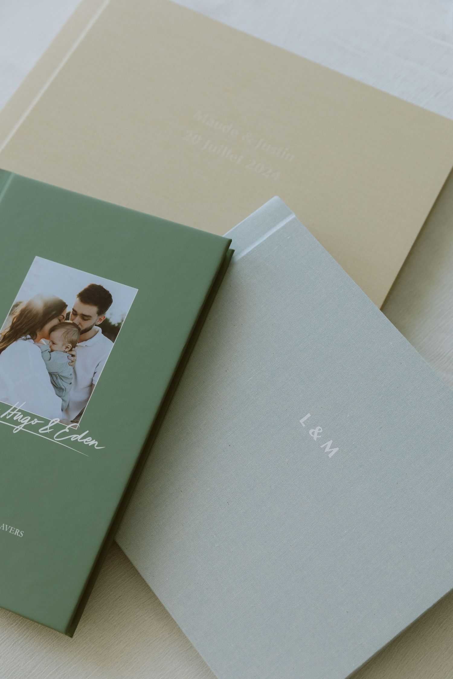 Trois modèles albums photos différents, couverture couleur vert sauge, beige, et bleur clair.