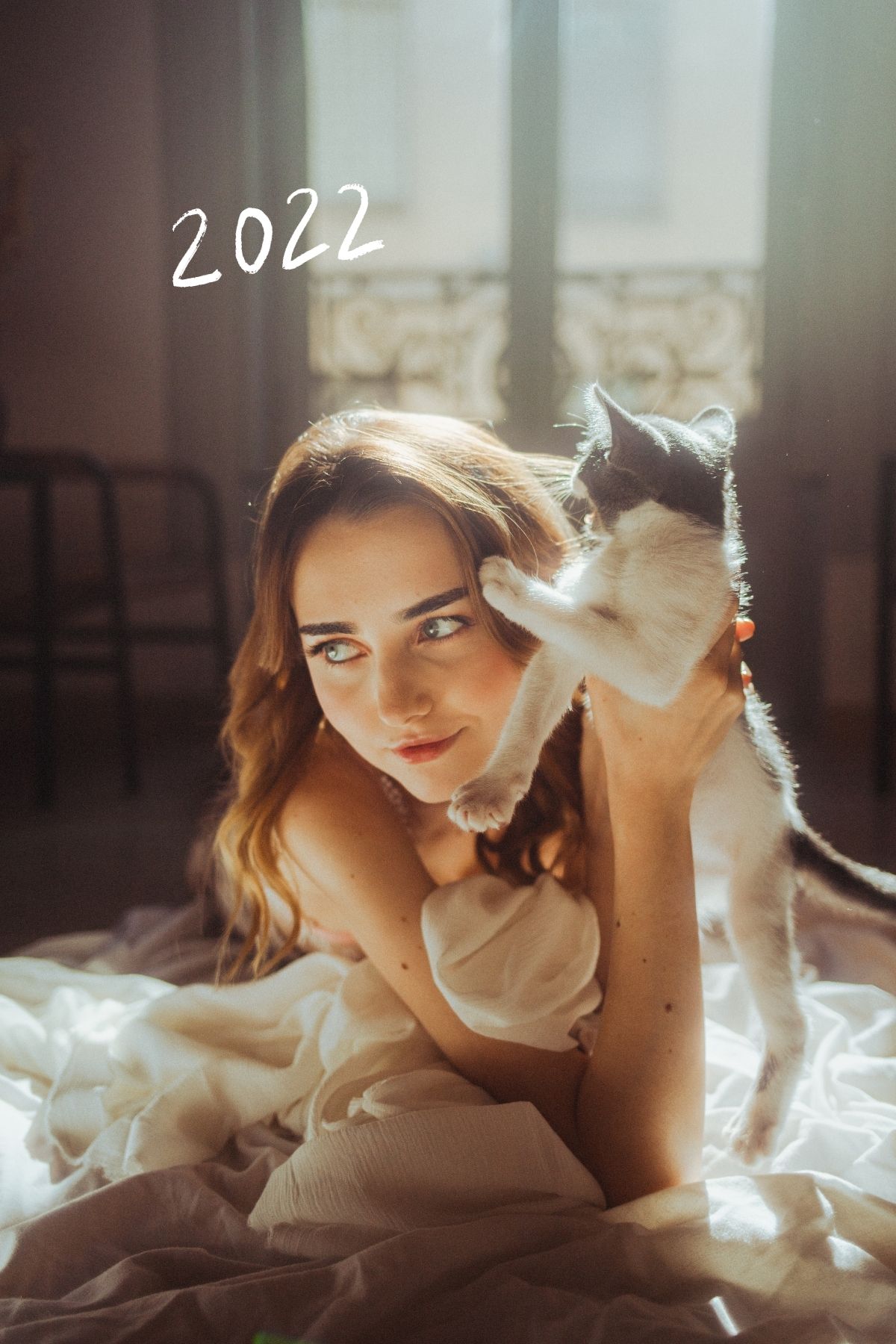 Fille joue avec son chat dans une pièce avec une belle fenêtre vintage parisienne.