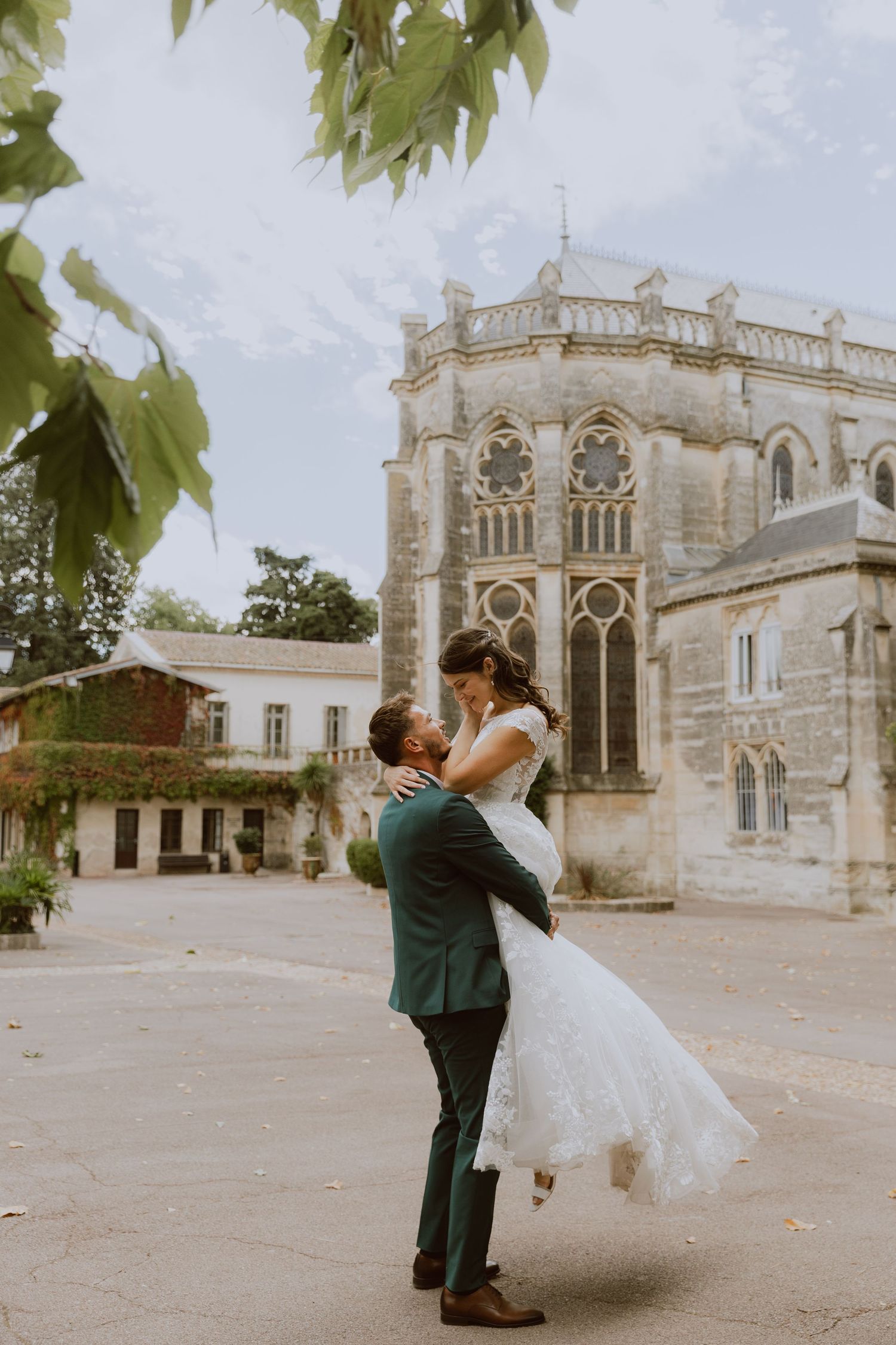 Couple de mariés qui se tient dans les bras devant l'église. Photographe Mariage à Montpellier.