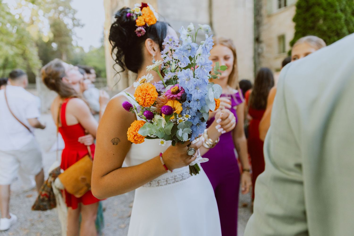 Une mariée tient un bouquet de fleurs naturel et coloré. Photo par Alice Enrico, photographe Mariage à Montpellier.