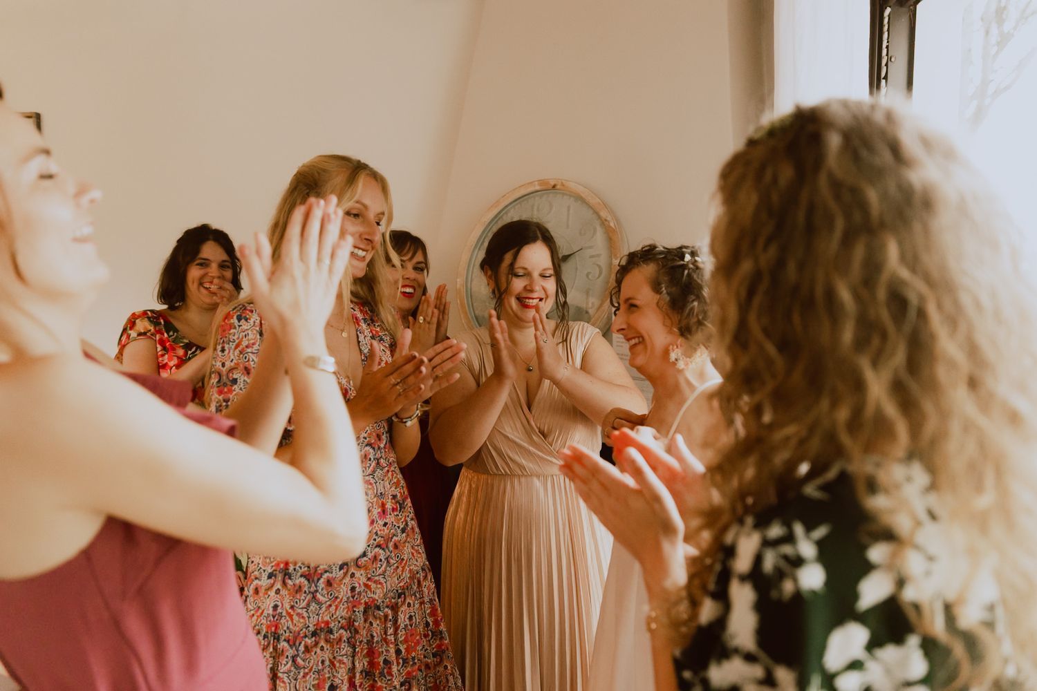 Les amies applaudissent la mariée pendant les préparatifs pour son mariage. Photo par Alice Enrico, photographe Mariage à Montpellier.